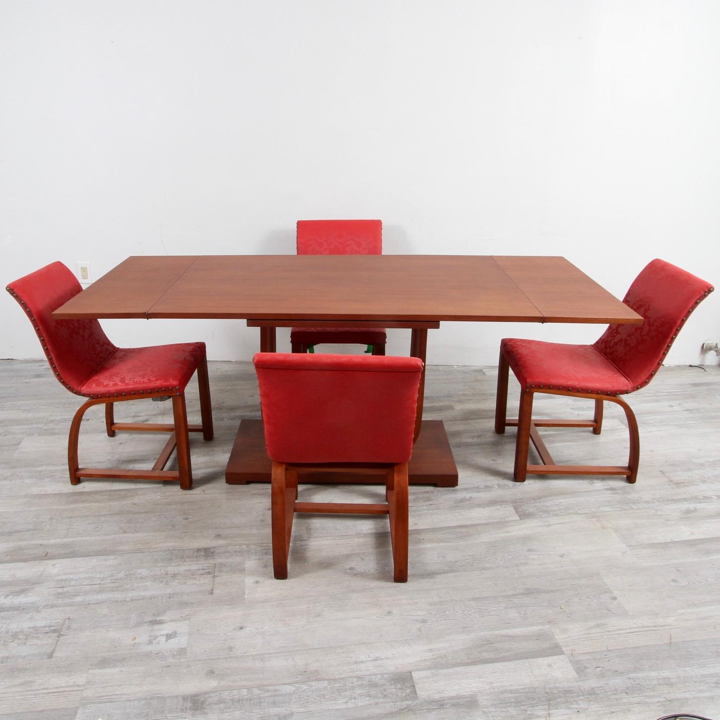 A walnut extension dining table designed by furniture and industrial designer Gilbert Rohde for Heywood Wakefield in the late 30s. This table came out of the original purchasers home. This came with the original 4 dining chairs that are in a