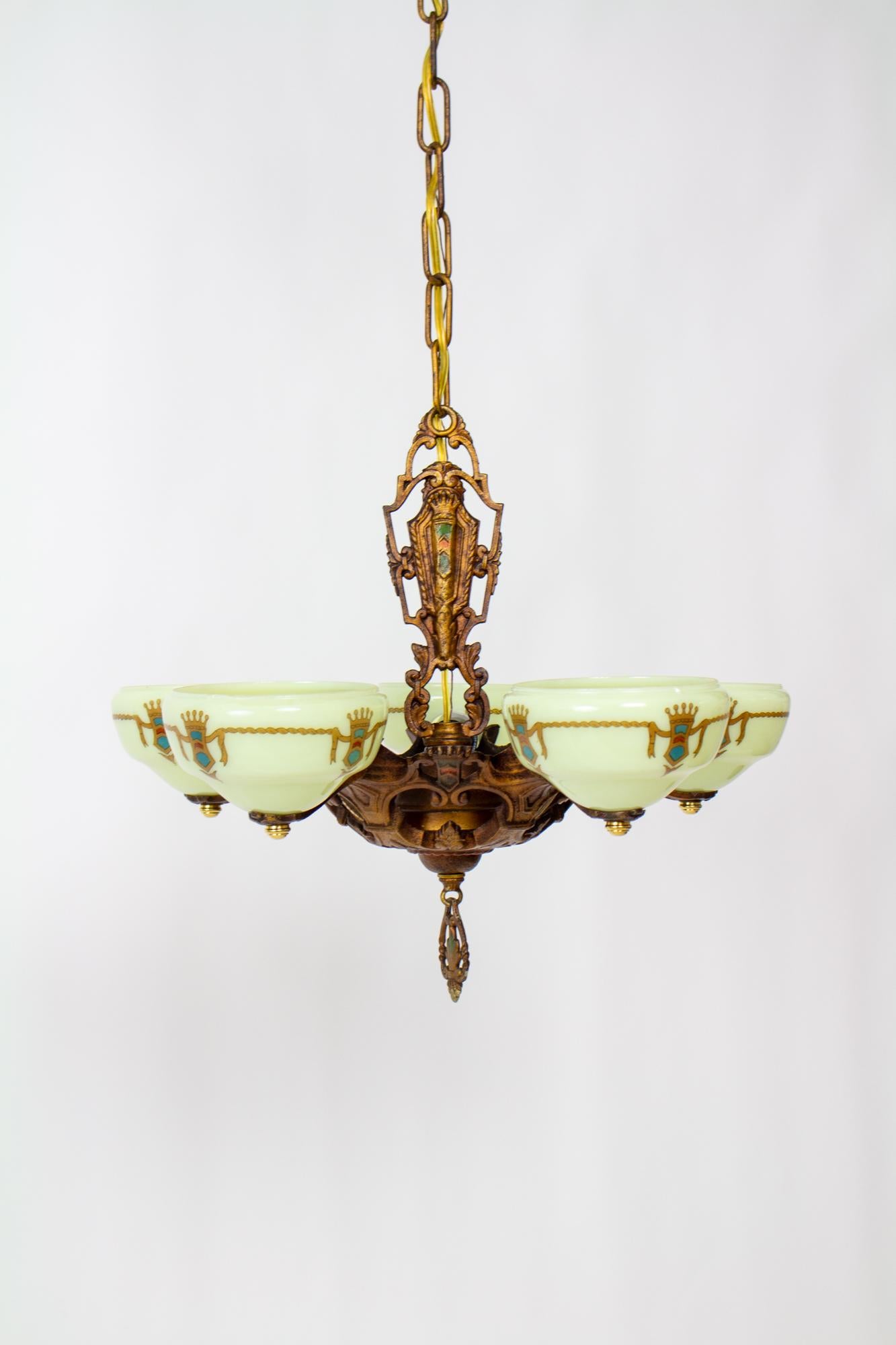 Art Deco gill glass chandelier with five arms and vaseline cup glass shades. Cast Iron frame with original polychrome painted finish. Art Deco / Renaissance Revival style. Glass shades are a unique bolted on cup style. Shades are Vaseline glass and