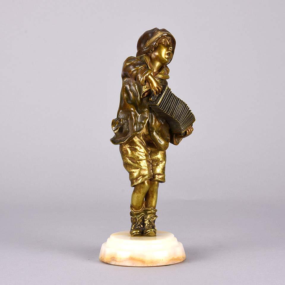 A delightful early 20th century gilt and enameled Art Deco bronze figure of a young lad playing the accordion, with wonderful detail and color, raised on a variegated onyx plinth, signed Chiparus on back of bronze.

Neighborhood children often