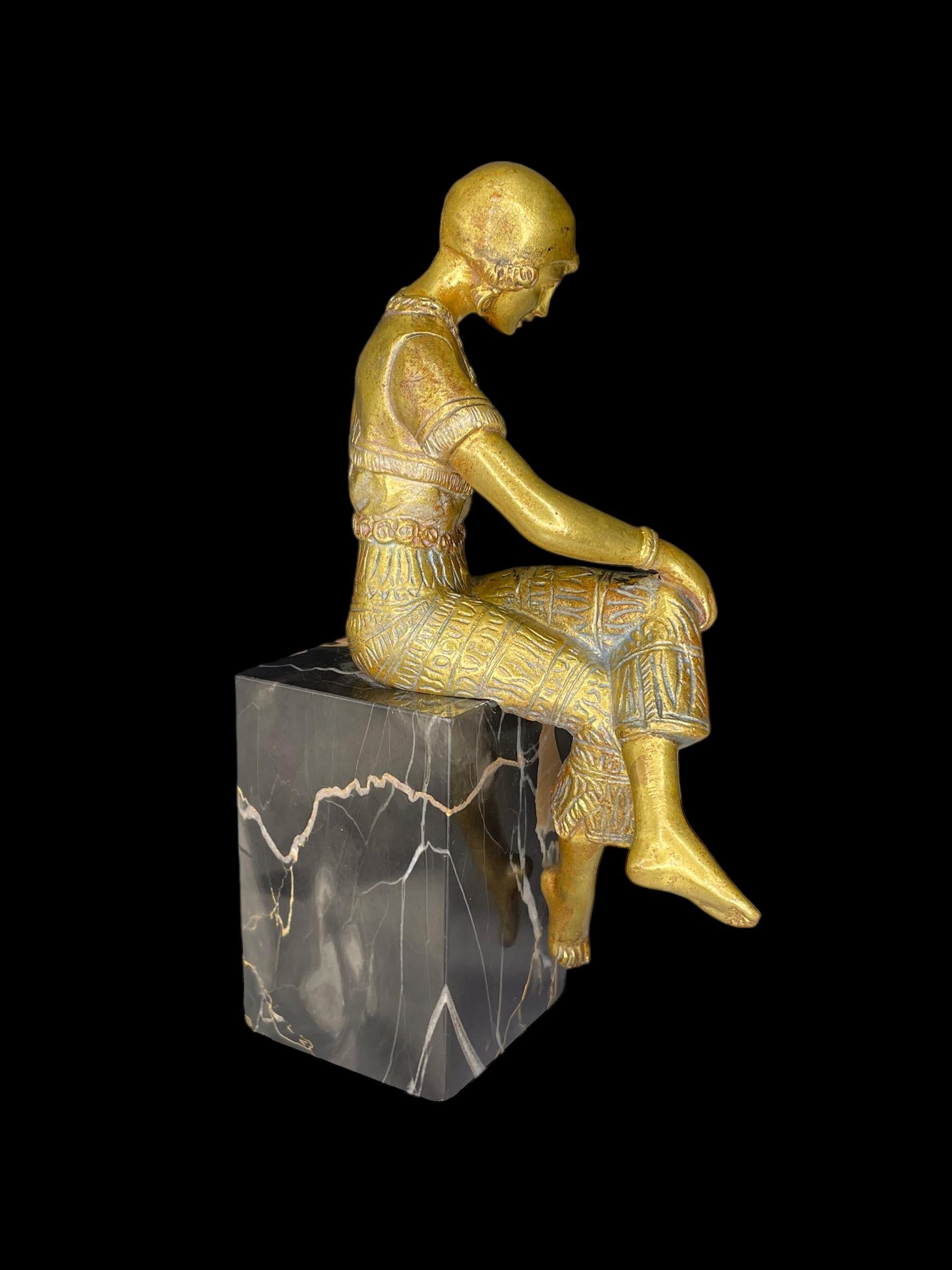Fille Art Déco en bronze doré, signée 'Jorel', et montée sur son socle original en marbre portoro de Belgique.
La jeune femme élégante est vêtue d'un pantalon de harem, le summum de la mode à l'époque, inspiré par l'influence du Moyen-Orient.