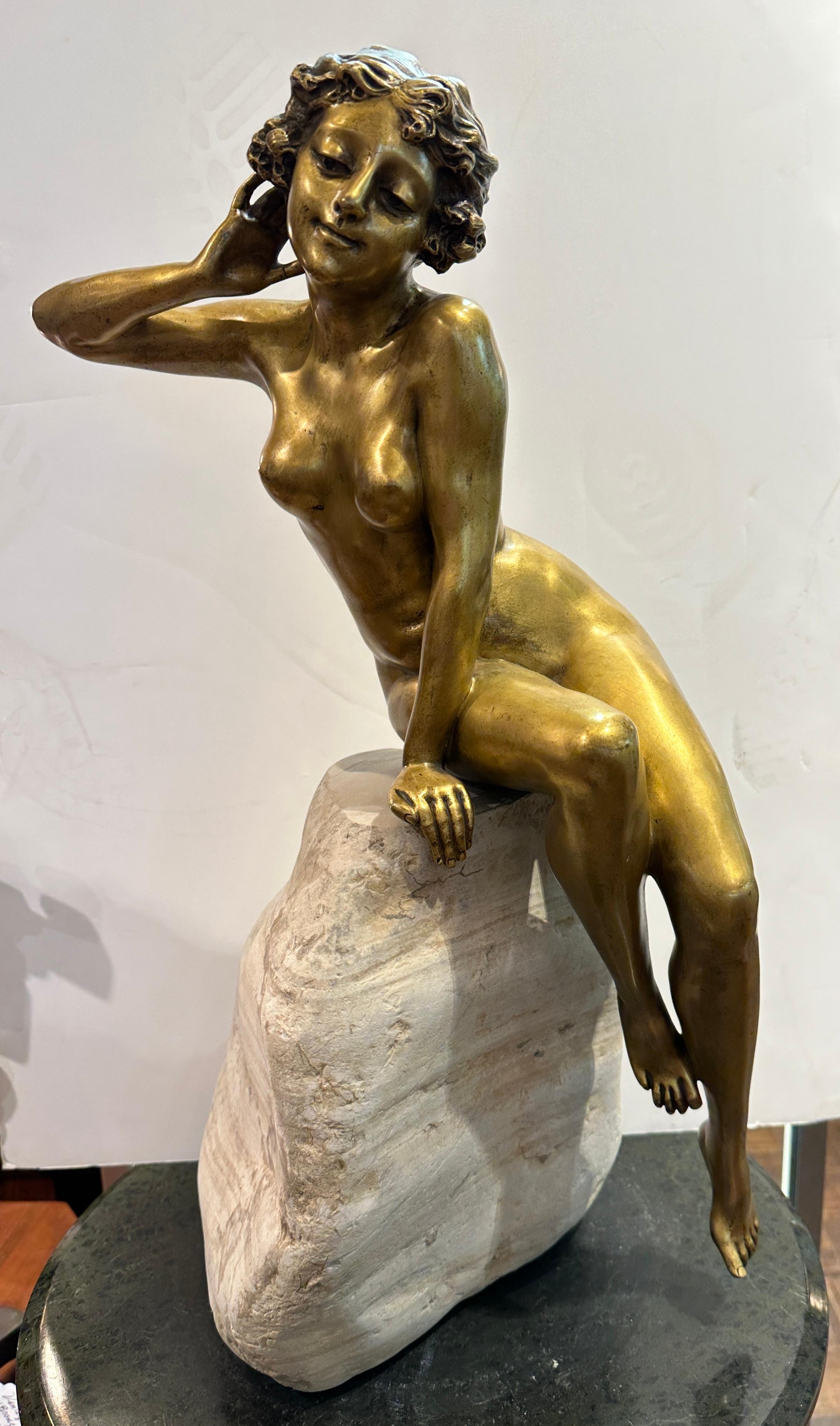 1900-1920, Beautiful female nude of bronze Dore.  Graceful nude lounging on a natural rock that has been newly replaced.  It is not the original one.  The gilt figure itself is in wonderful condition.  
Rock, 10x10x 8”high is a replaced rock