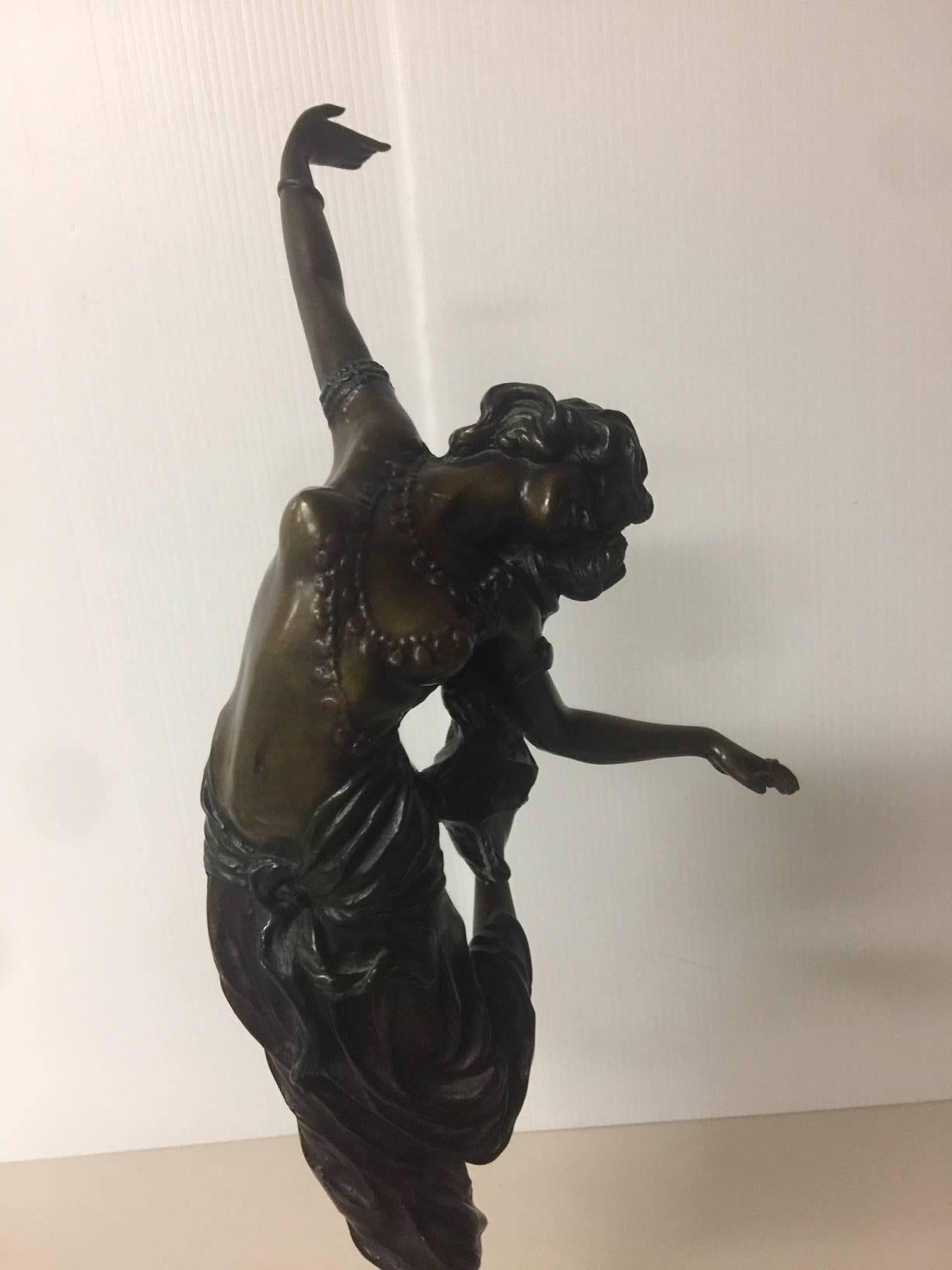Stunning Art Deco patinated gilt bronze statue entitled 'Oriental Dancer' by Claire Jeanne Roberte Colinet, circa 1920s. The dancers long hair winding down her back, bare breasted with a selection of necklaces and harem pants, one leg raised mid