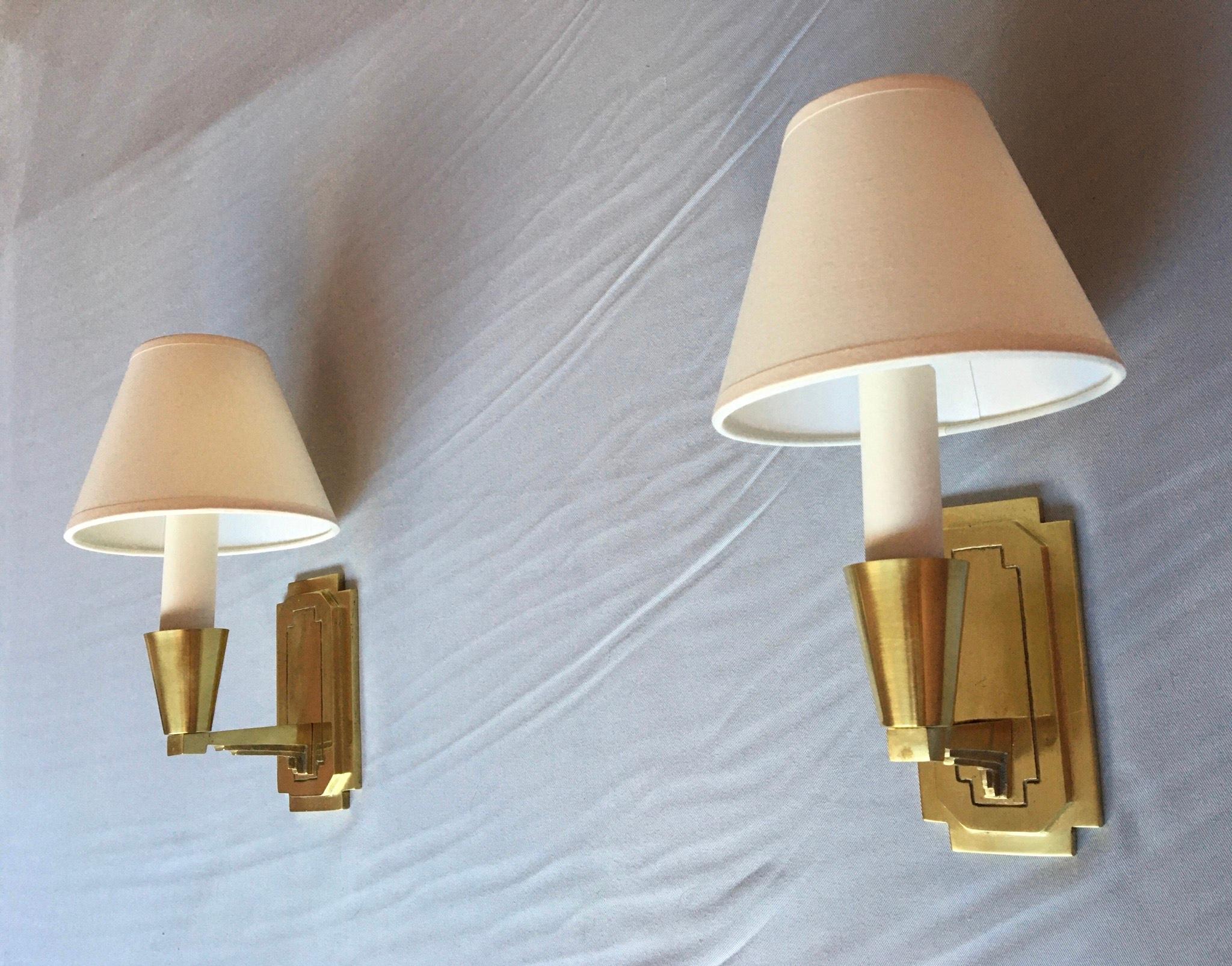 Beautiful pair of French Art Deco period of the 30's gilted bronze sconces.
The pair is in a very good condition, stamped A B and numbered on the backplate, electrical parts have been renewed and fit the US standard. The ivory white cotton Lamp