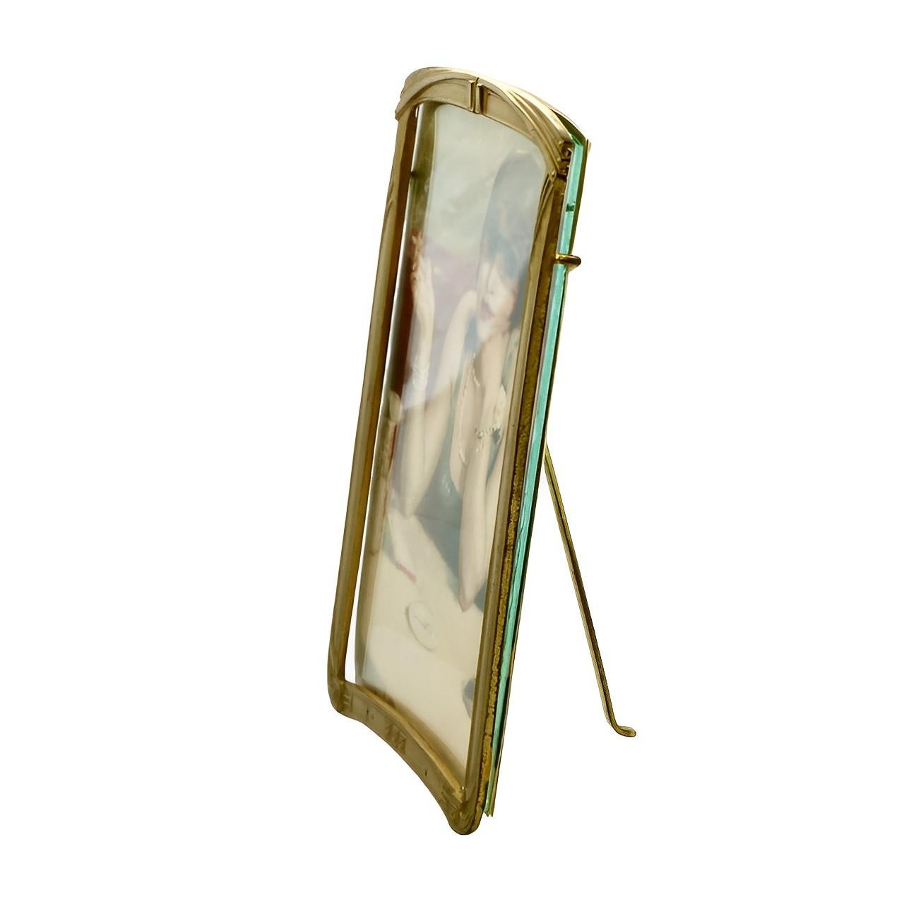 Lovely Art Deco gilt metal picture frame in a classic design, with inset glass and a picture of a flapper. The frame has a metal support support arm which works well.

Measuring width 12.1 cm / 4.76 inches by height 17.6 cm / 6.9 inches, and depth 5