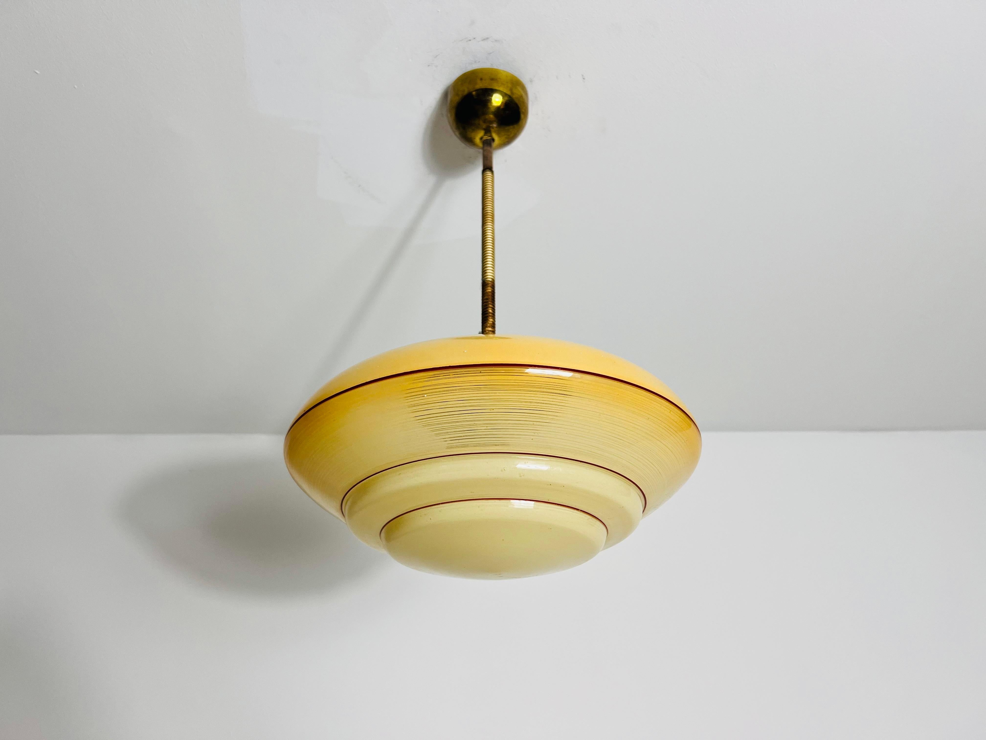 Bellissima lampada a sospensione in vetro degli anni '30, realizzata in Germania. La luce morbida e diffusa che passa attraverso il vetro venato crea un'atmosfera calda e invitante, rendendolo un perfetto centrotavola per qualsiasi stanza. Il suo