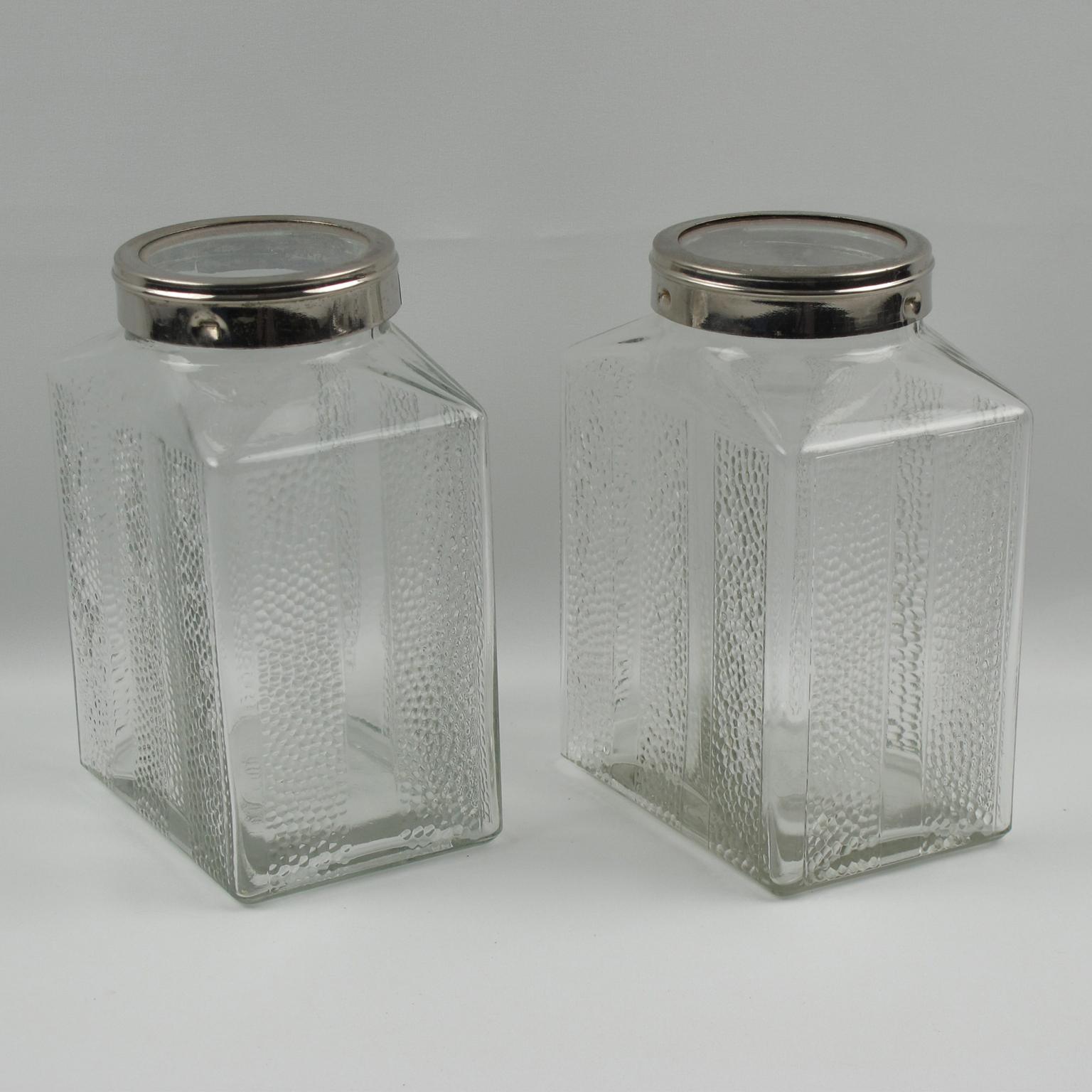 A lovely Art Deco kitchen canister jar set of two pieces. They feature a large-size container with a geometric shape. The molded glass container with a typical Art Deco design is topped with a screw lid in chromed metal. Marked underside: Allemagne