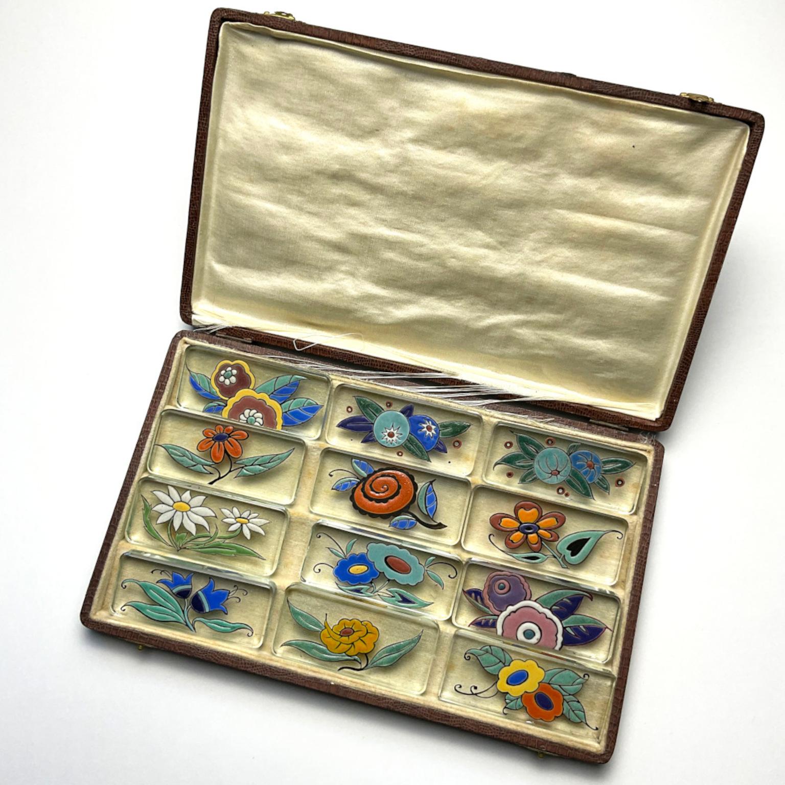 Original box of 12 beautiful c1925 enameled glass knife rests by Maison Delvaux with Polychrome Flower Decoration.
Unsigned
DELVAUX was a prestigious porcelain and crystal retail store, located at 18 rue Royale in Paris. Founded in the 1880s, it