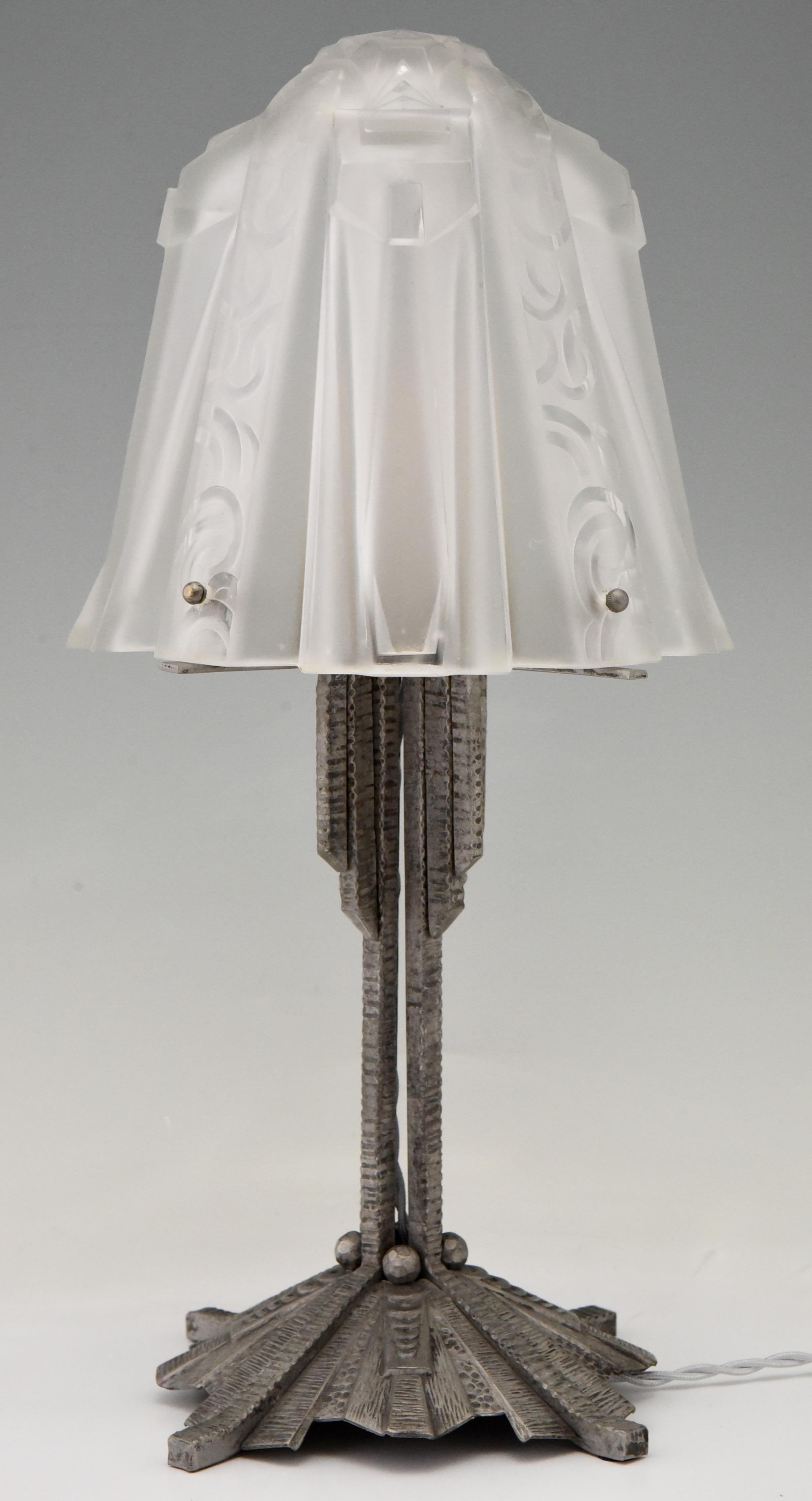 Fine Art Deco glass and iron table lamp by Muller Frères Lunéville. 
Glass shade with geometrical forms in relief on a fine wrought iron base with silver patina. France 1925. 
Literature:
“Glass, Art Nouveau to Art Deco” by Victor Arwas, Academy.