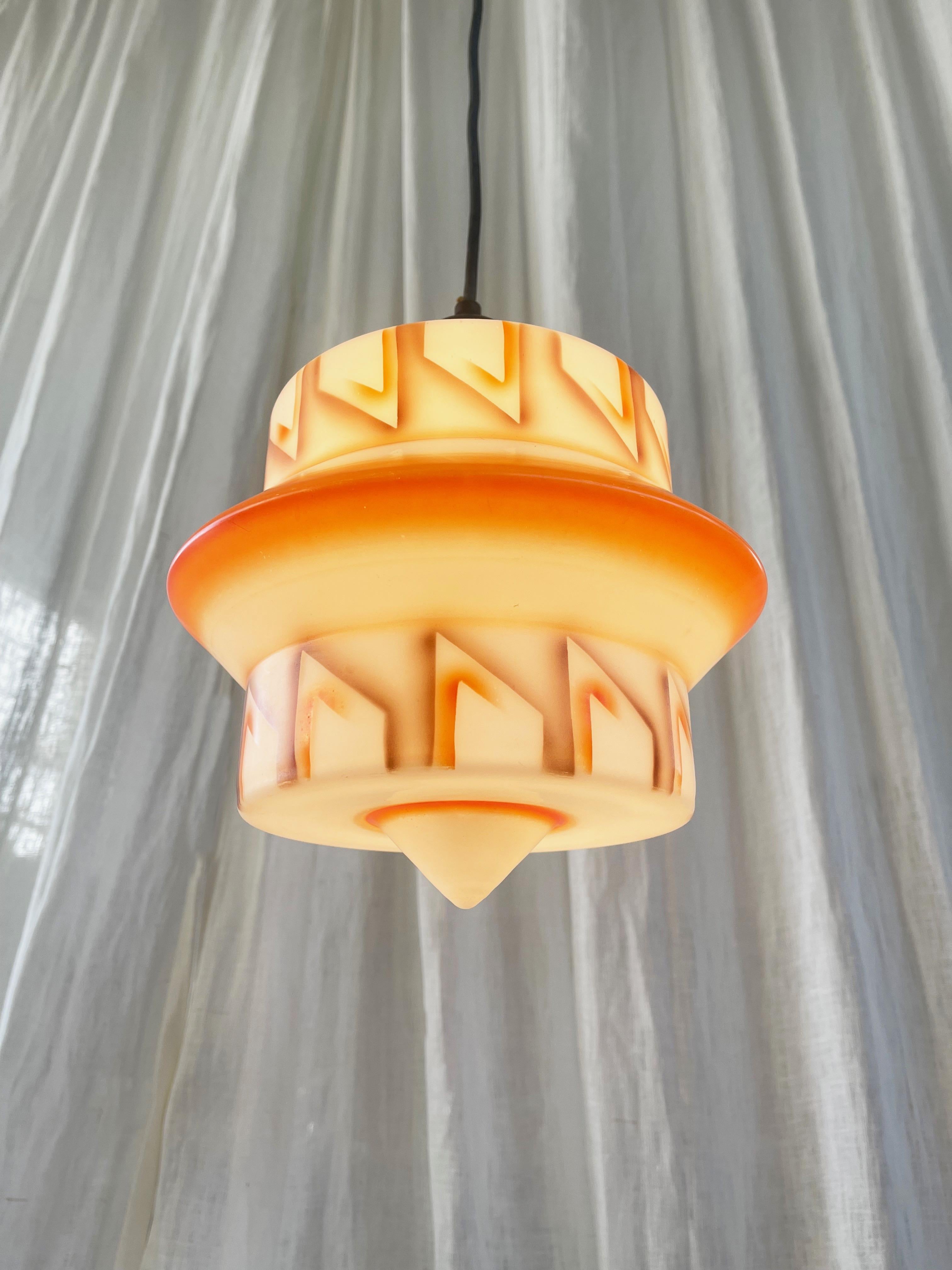 Decorazione spray arancione e marrone realizzata a mano su vetro smerigliato bianco. 
Ferramenta originale in ottone patinato.
Fantastico pezzo d'arte e design degli anni '30, Germania o Austria.

Funziona perfettamente, la lampadina è un attacco a
