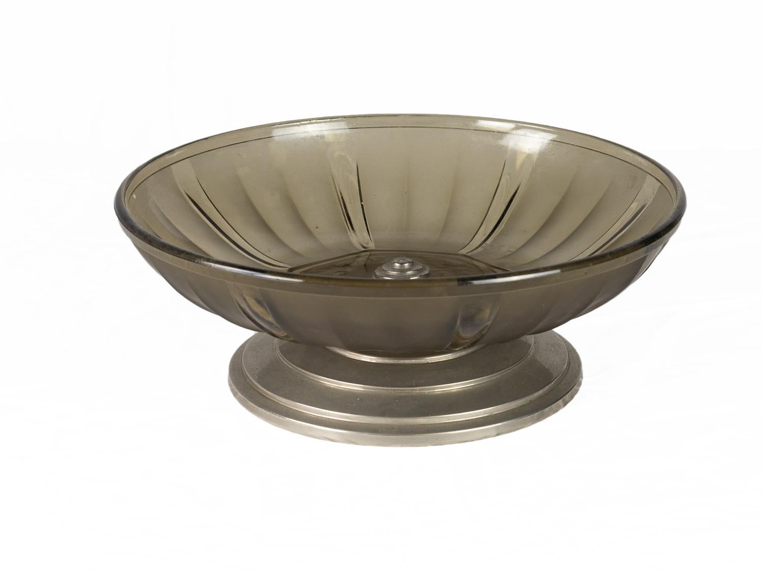 Un centro de mesa de cristal grisáceo ahumado con base de metal con pedestal
