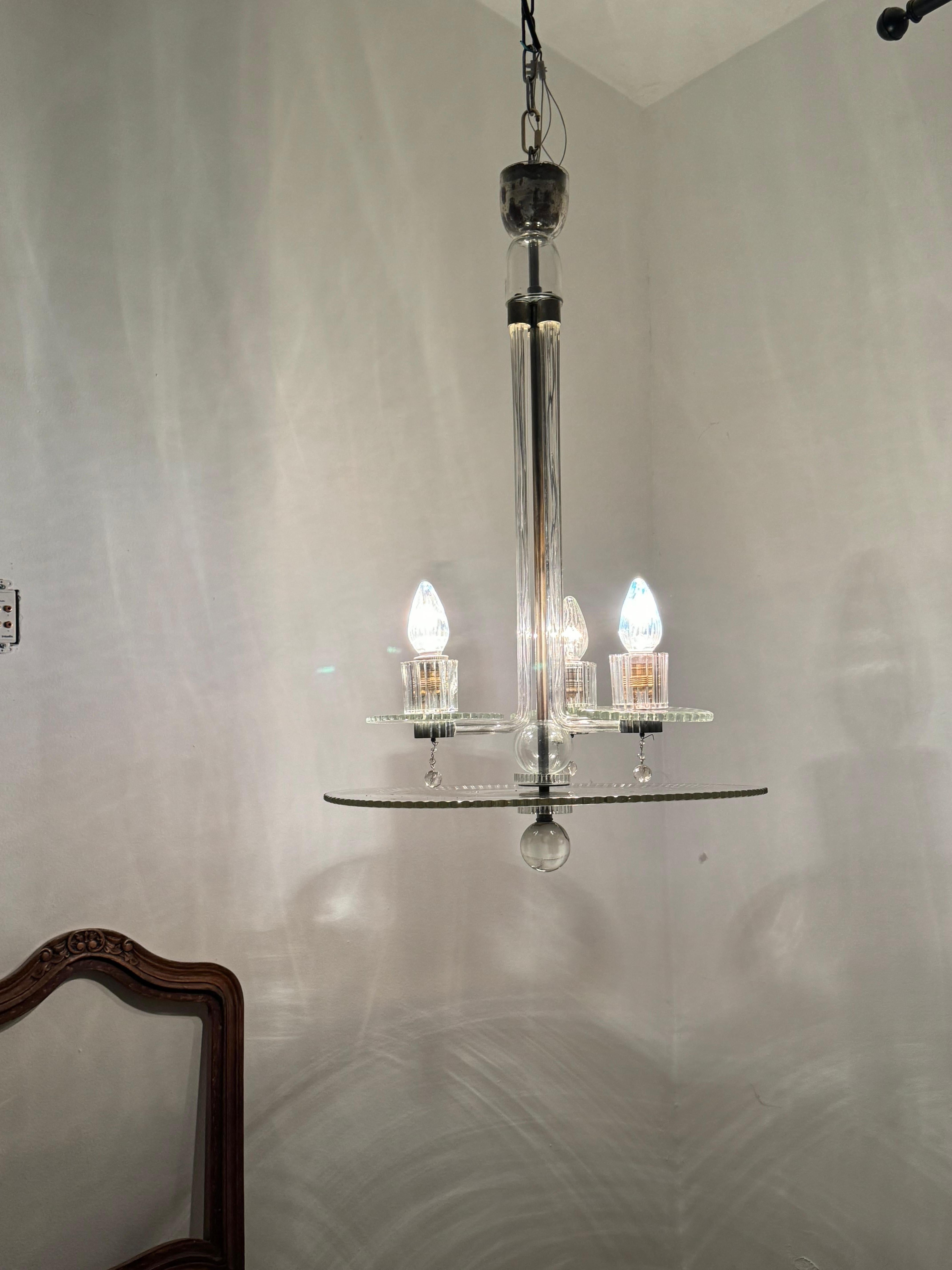 Beautiful  3 light chandelier manufactured in hand carved glass.
This is a very unique chandelier as we have not come accross something similar before.
Measures 85 cm tall and 51 cm wide (disk´s diameter)
The top cup of the chandelier has a mirror