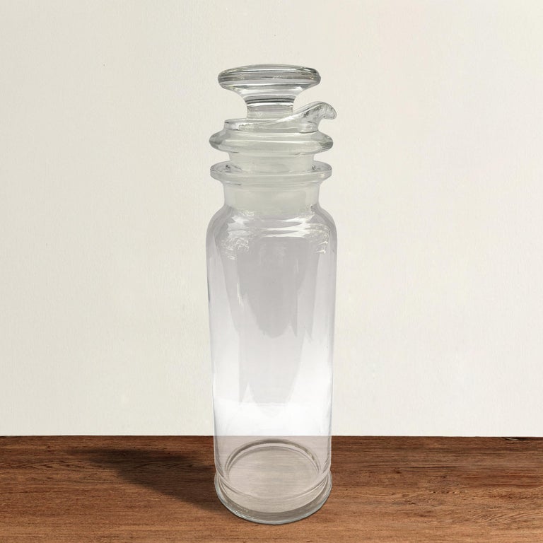 A chic early 20th century American Art Deco glass cocktail shaker with removable glass stopper and glass strainer. For the purist at heart, this shaker gives you a behind-the-scenes look at how a couple shots of liquor, some fruit juice, and some