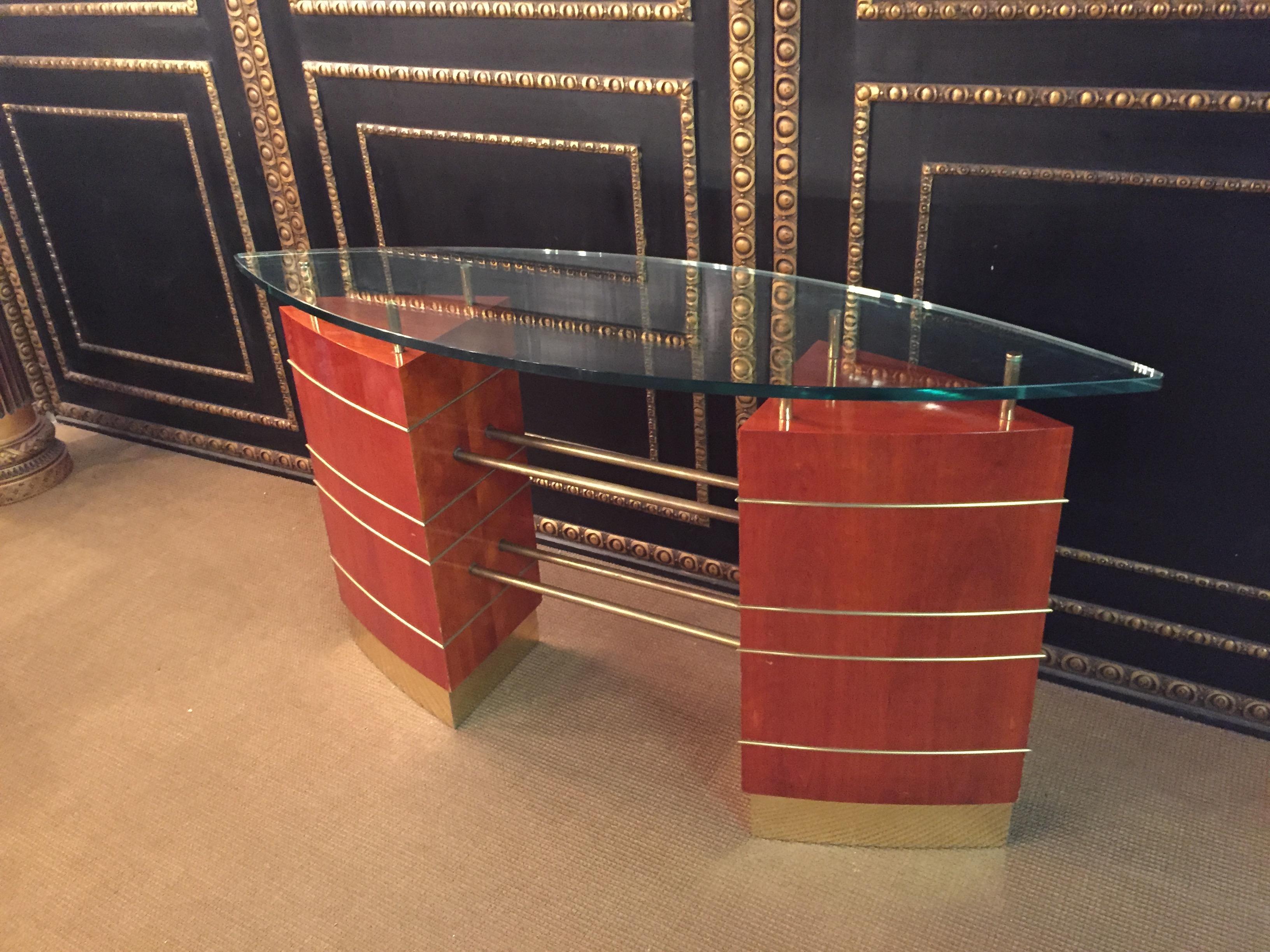 Art Deco glass desk or reception table.
Unique table in Art Deco style.
Oval glass plate tapering at each end.
Precious veneer framed with brass.
in the middle with brass struts.
The glass plate has small damages.