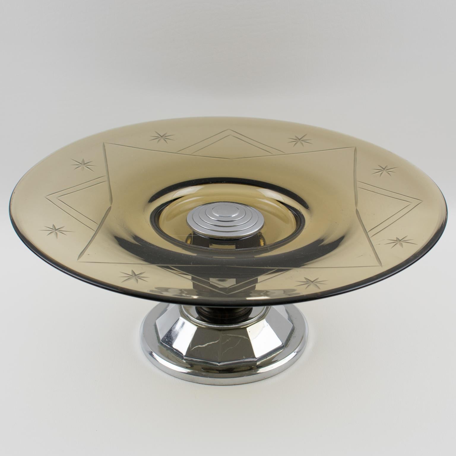 Questo elegante centrotavola decorativo o ciotola da portata in stile Art Decor modernista francese presenta una grande ciotola rotonda in vetro con un motivo inciso in un bel colore grigio fumo trasparente. Il pezzo è stato realizzato nel 1930