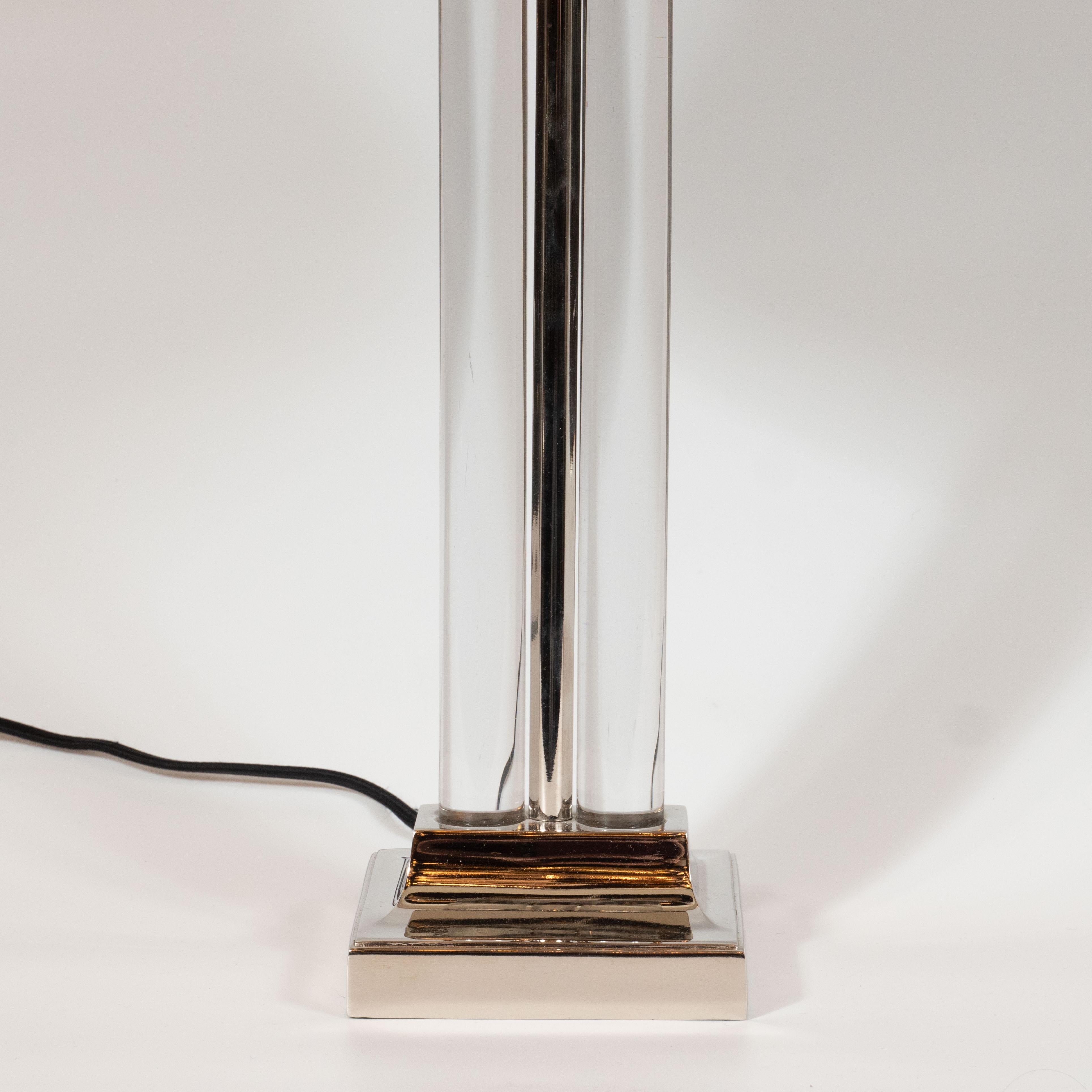 This elegant table lamp was designed by the esteemed Gilbert Rohde- one of the pioneers of Modern design in America- for MSLC circa 1940. It features a tiered nickel base with a cylindrical column rising from the center flanked by two translucent