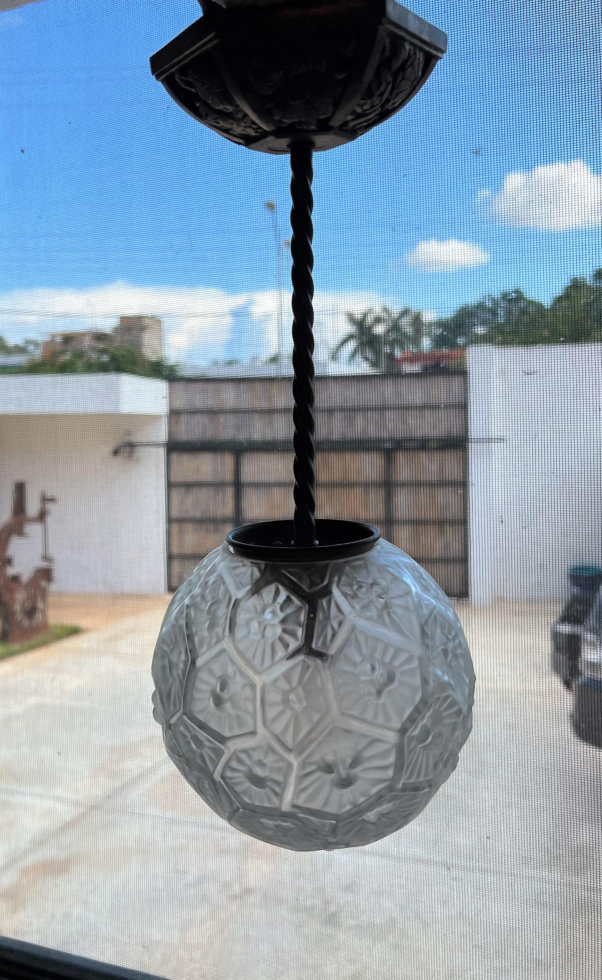 Small pendant light manufactured in France circa 1940, in pressed glas and nickel plated metal.
The nickel plating shows patina, this can be re done by us if client chooses to.
It takes 1 bayonette bulb. 
Height :36 cm or 14.2 inches
Diameter of