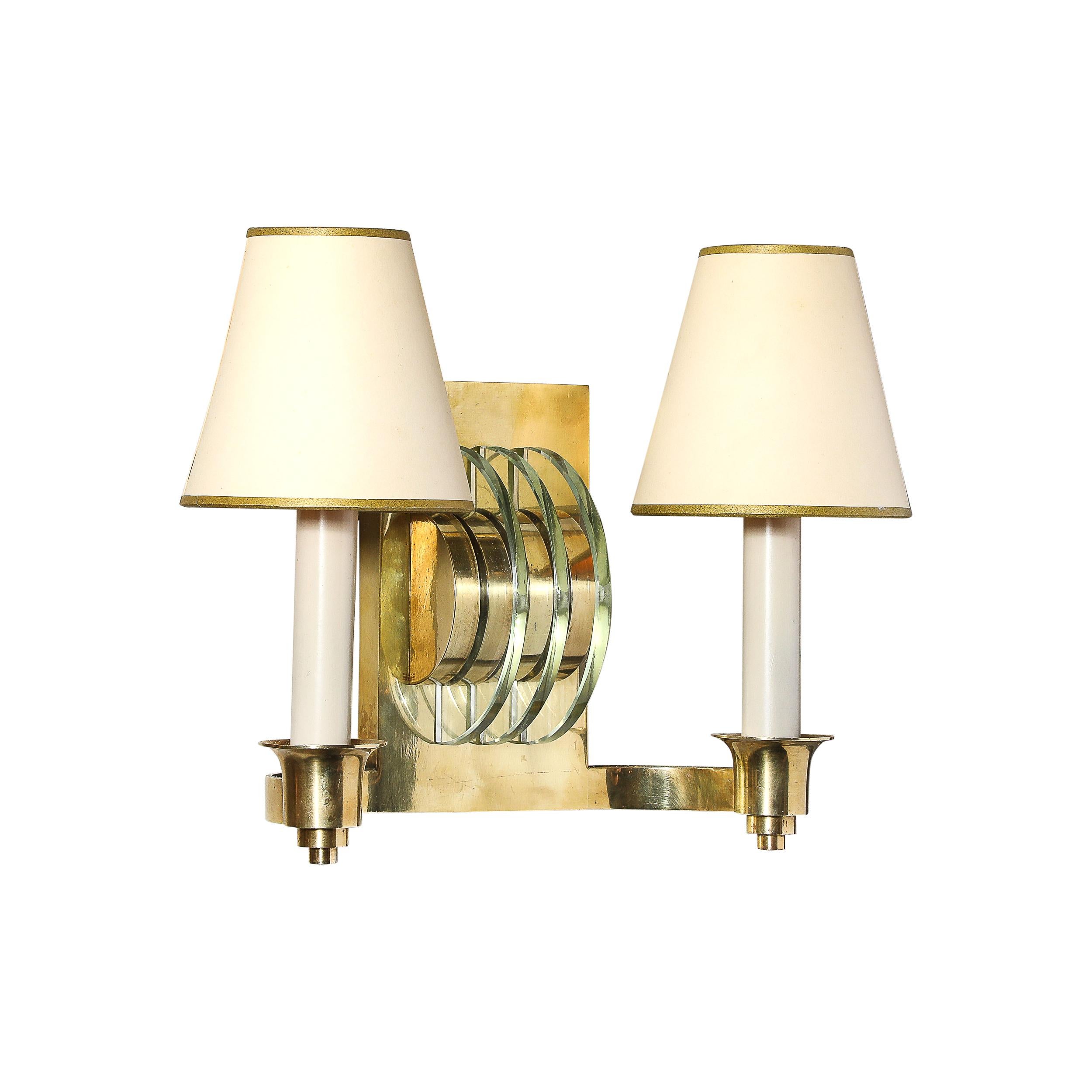 Questa elegante coppia di appliques Art Déco, creata dagli stimati designer francesi Genet & Michon intorno al 1935, mette in mostra lo stile iconico dei grattacieli dell'epoca in una forma calda e accattivante. Ogni applique presenta elementi in