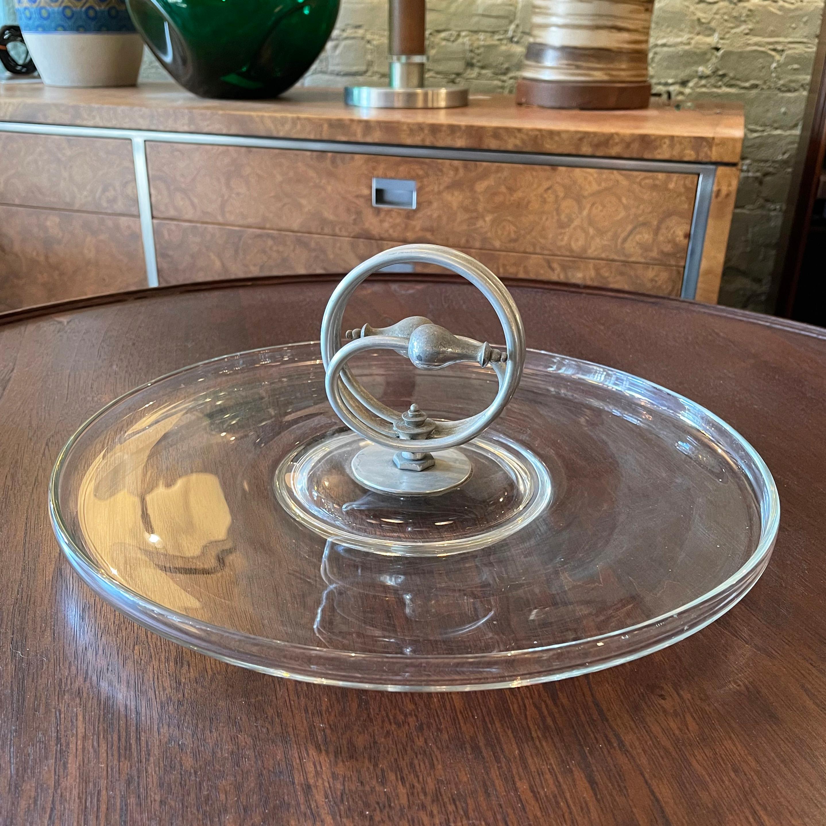 Art Deco, glass serving platter dish features a decorative, colied aluminum handle.