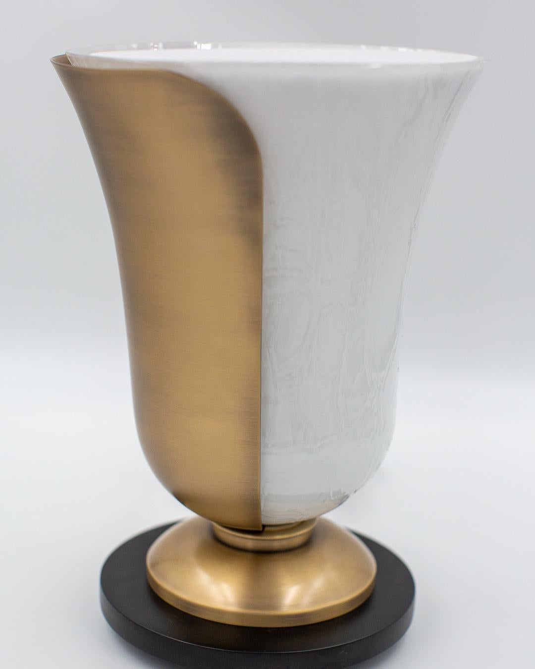 Lampe à poser en verre opalin texturé avec petit diffuseur à poser ou non sur le dessus.
Cette lampe en forme de coupole est délicatement recouverte une un coté par un pétale en bronze finition antique. Son socle est de la même finition. Pour ce