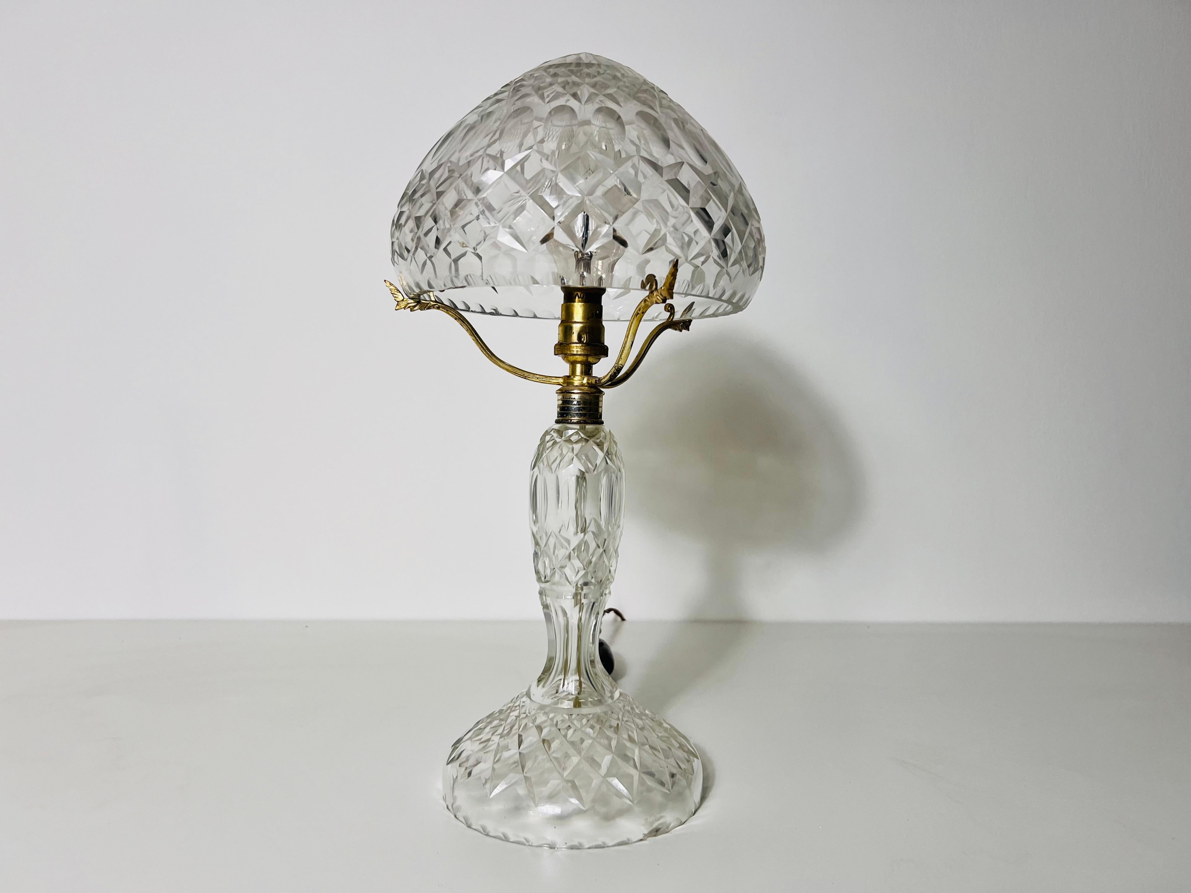Esta lámpara de sobremesa Art Déco vintage de los años 40 es un impresionante ejemplo del diseño artístico y la artesanía de la época. Fabricada en vidrio soplado, la lámpara encarna la audacia y elegancia características del Art Déco, un estilo que