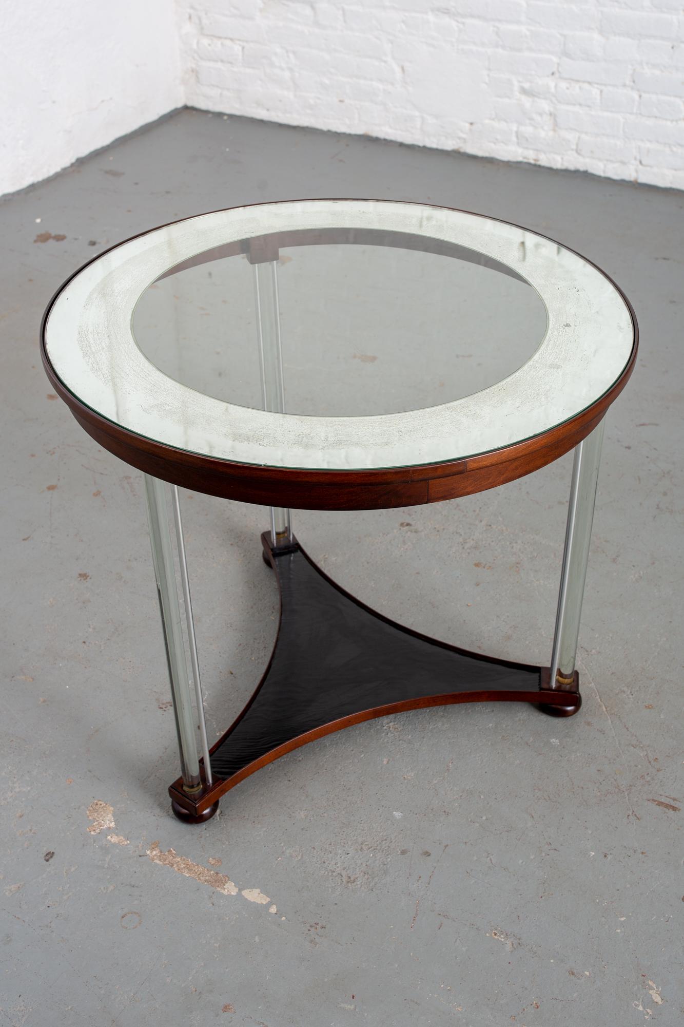 Round Art Deco American 1950s glass top table with glass legs and painted base. Table has very unique and beautiful glass legs that are reinforced by steel rods. Antique mirror top edged with distressed silver leaf. Mahogany wood base in espresso