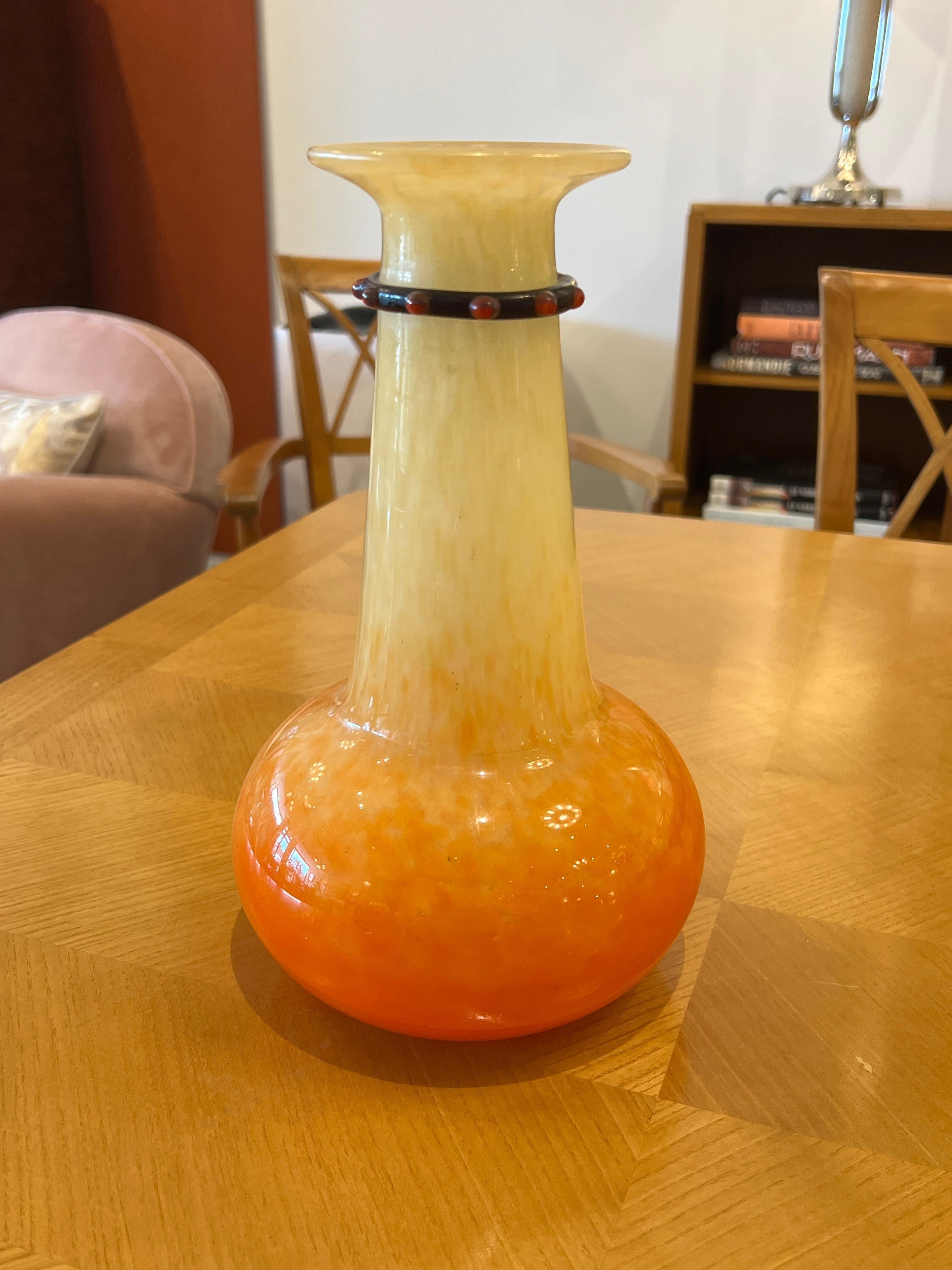 A French Art Deco glass vase by Charles Schneider in orange and yellow hues with a glass application around the neck.
Signature: Schneider-France
Charles Schneider was a renowned glassmaker during the Art Deco period in France. He was known for his