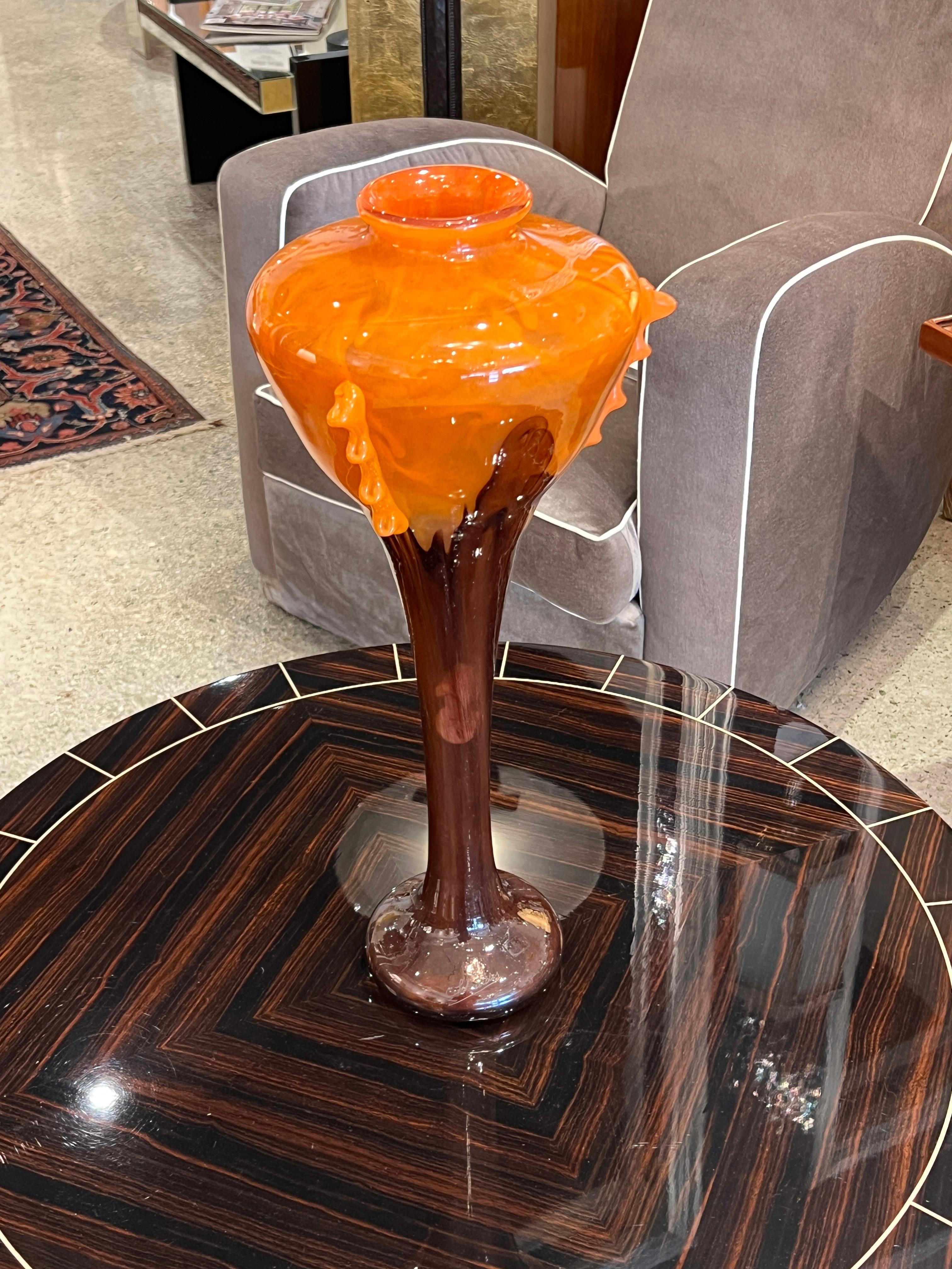 Vase Art déco en verre élancé dans des teintes orange brûlé avec des détails d'applications orange vif sur les côtés de la pièce.

Signé par Schneider.
