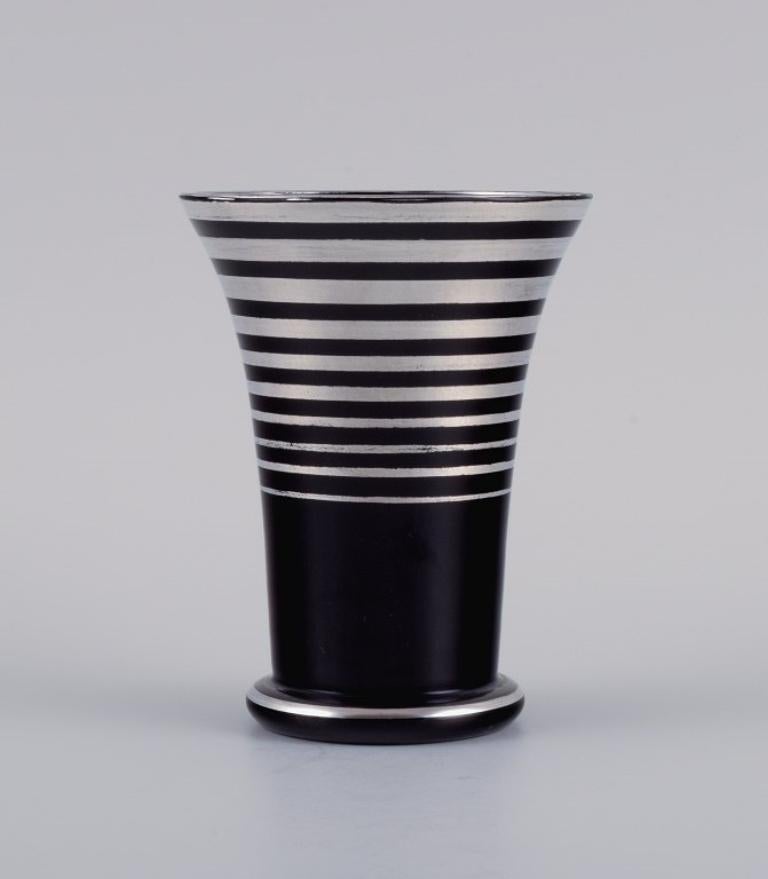 Vase en verre Art déco, Allemagne. Avec incrustations horizontales en argent.
Les années 1930-1940.
En bon état avec une usure mineure.
Dimensions : H 10,5 x P 8,0 cm : H 10,5 x D 8,0 cm.