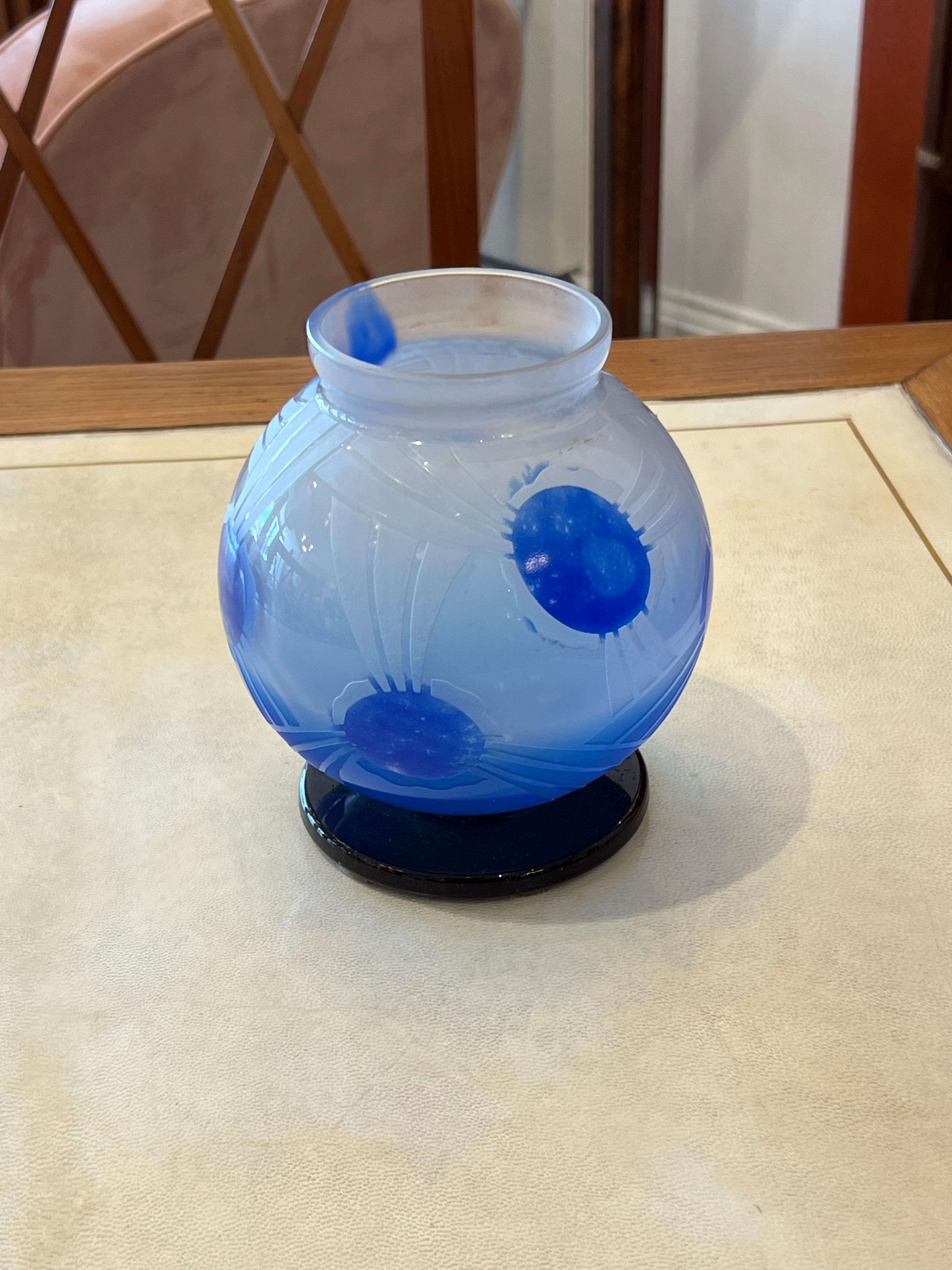 Un vase en verre à fond clair avec quelques touches de dégradé de bleus qui font ressortir le motif.  Ce motif floral géométrique est sablé et gravé à l'acide.  Cette pièce appartient à la série Décor du Verre Français.
Signature : Le Verre