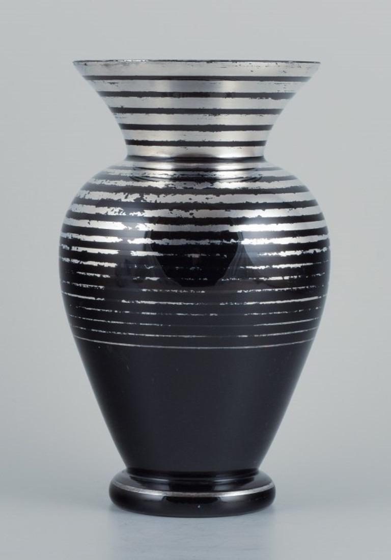 Art Deco glass vase, Germany. With horizontal silver inlays.
1930/40s.
In excellent condition with minor wear.
Dimensions: H 24.5 x D 13.5 cm.