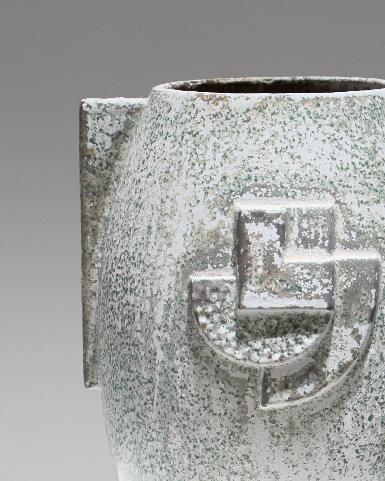 Vase Art Deco en céramique émaillée et fonte de fer, teinte bleu/vert, ornés de motifs géométriques en relief. Texture légèrement brute, aspect et usure du revêtement normaux. En bel état.