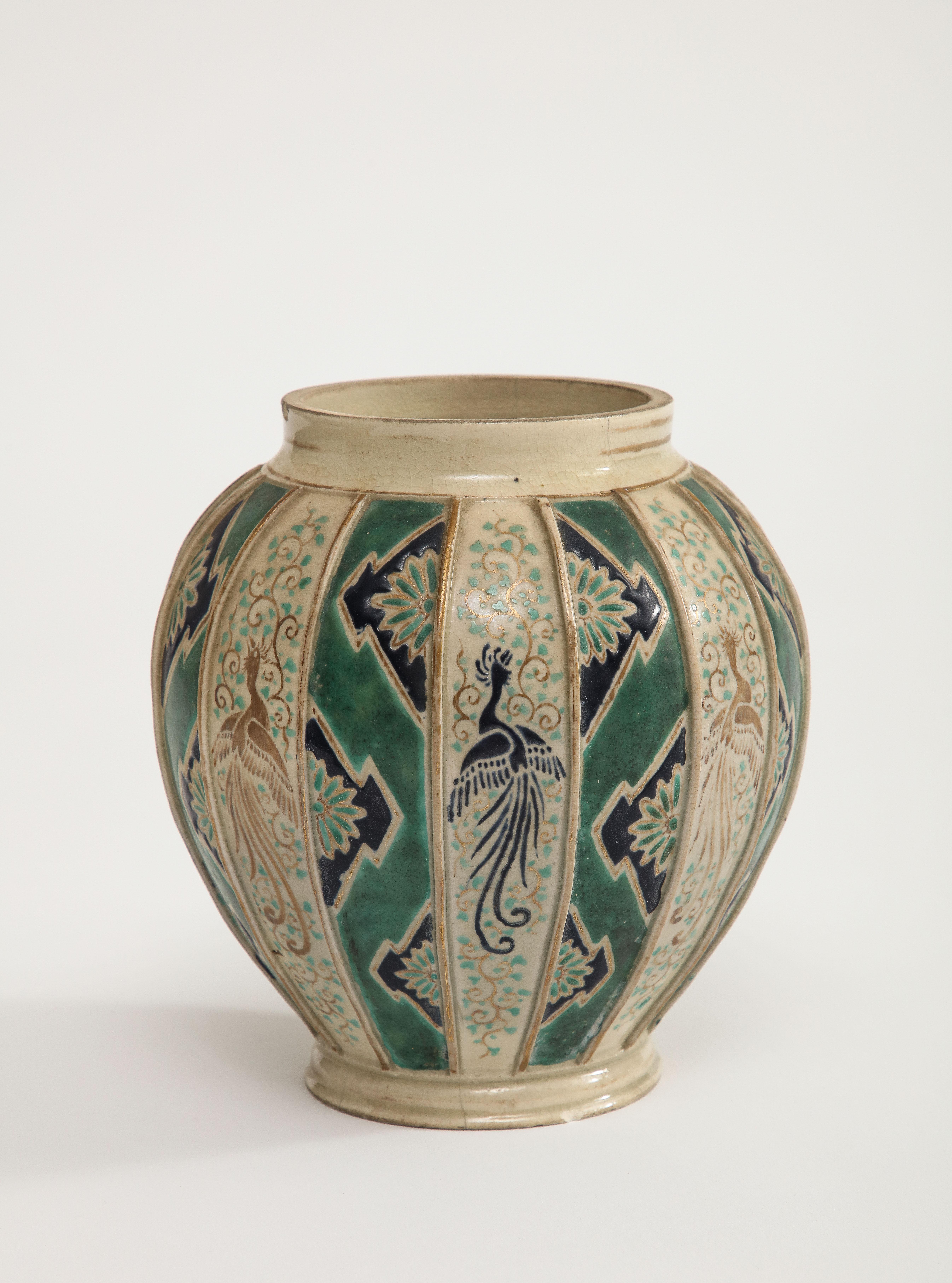 Vase en poterie Art Déco, peint à la main avec un motif d'oiseaux en vol sur un fond naturel alternant avec des bandes émaillées vertes. Allemagne, années 1920. 