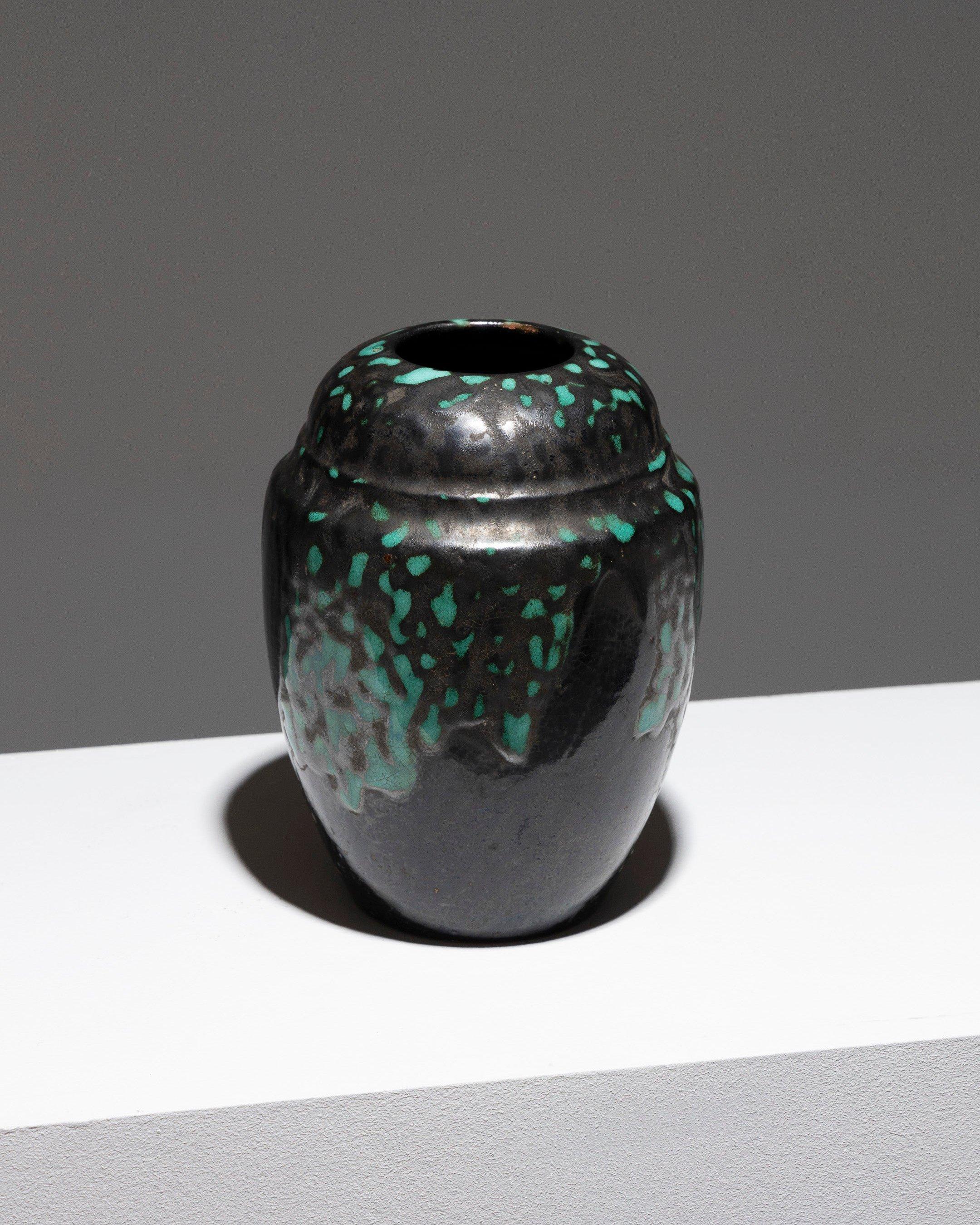 Vaso a spalla in ceramica smaltata di CAB per Primavera, in stile Art Deco degli anni '30. Presenta un collo piatto e inclinato verso l'interno con un motivo irregolare a macchie verde rame su uno sfondo nero metallizzato. Marchi impressi sulla
