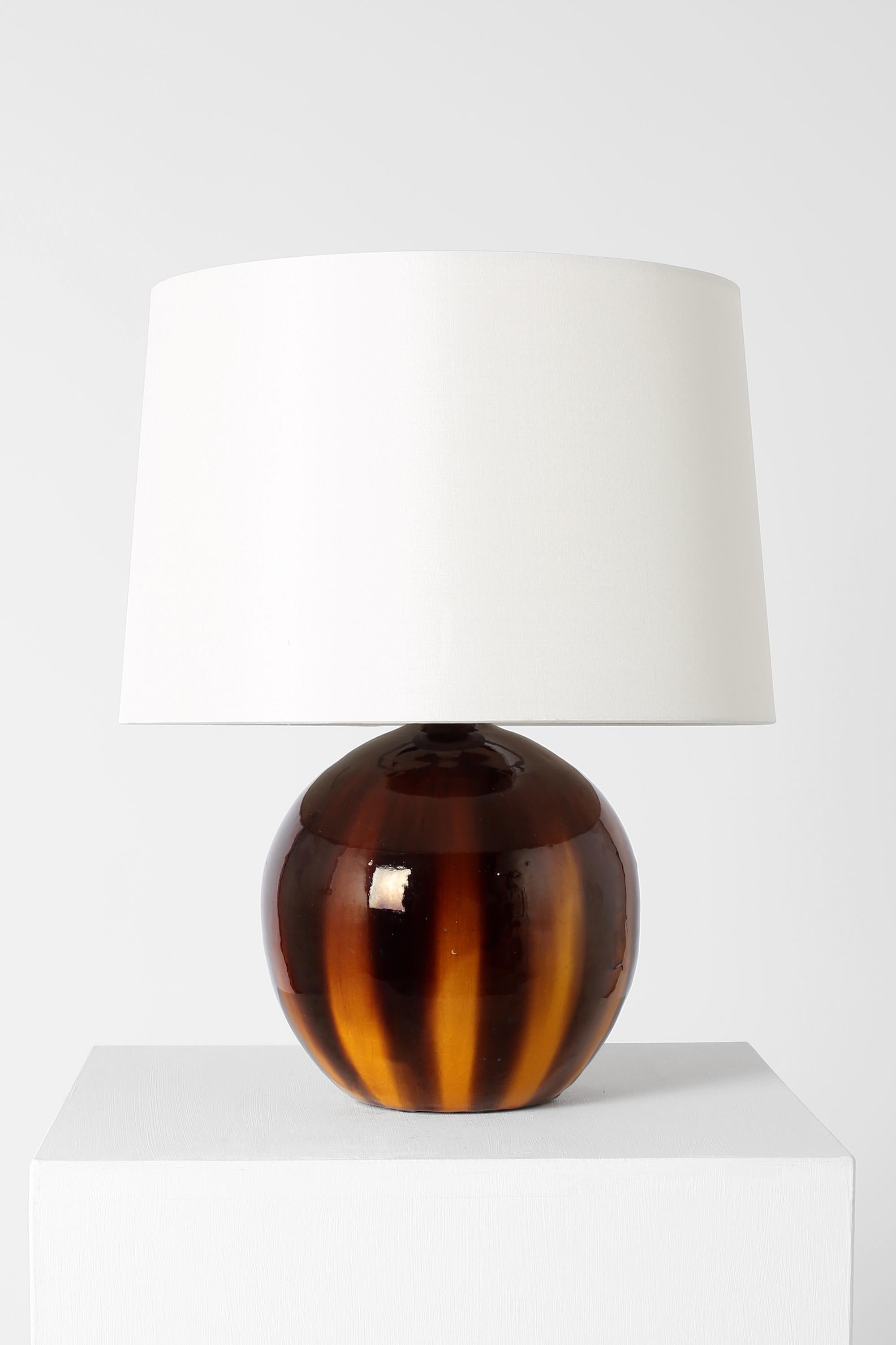A rare terracotta table lamp of spherical form, with toffee-like ochre and brown crackle glaze by Albert Heilles for his atelier in Albi, signed. French, 1931. Supplied with an off-white dupion silk shade.