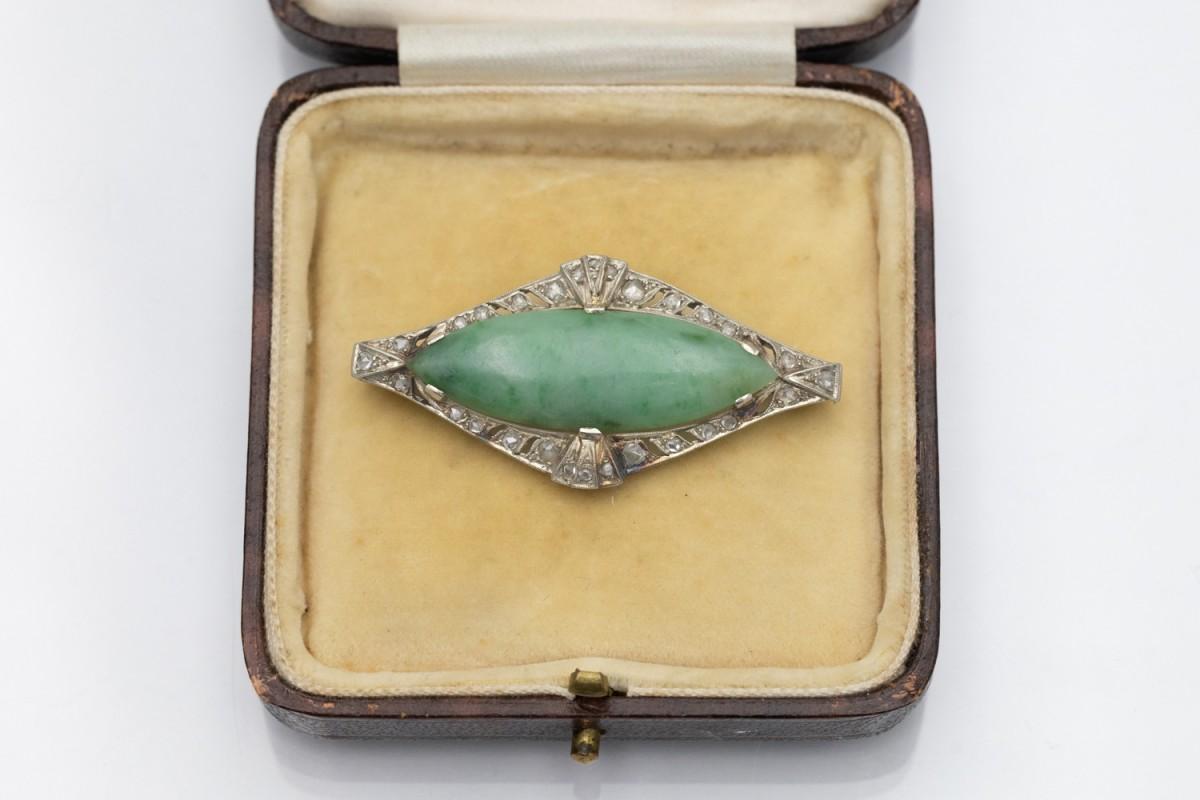 Broche unique de style Art Déco, de forme allongée, avec des diamants et du jade vert. La broche est en or blanc 14 carats (titre 0,585). La broche est décorée de 28 rosettes de diamants d'un poids total d'environ 0,22 ct.

Origine : France, vers