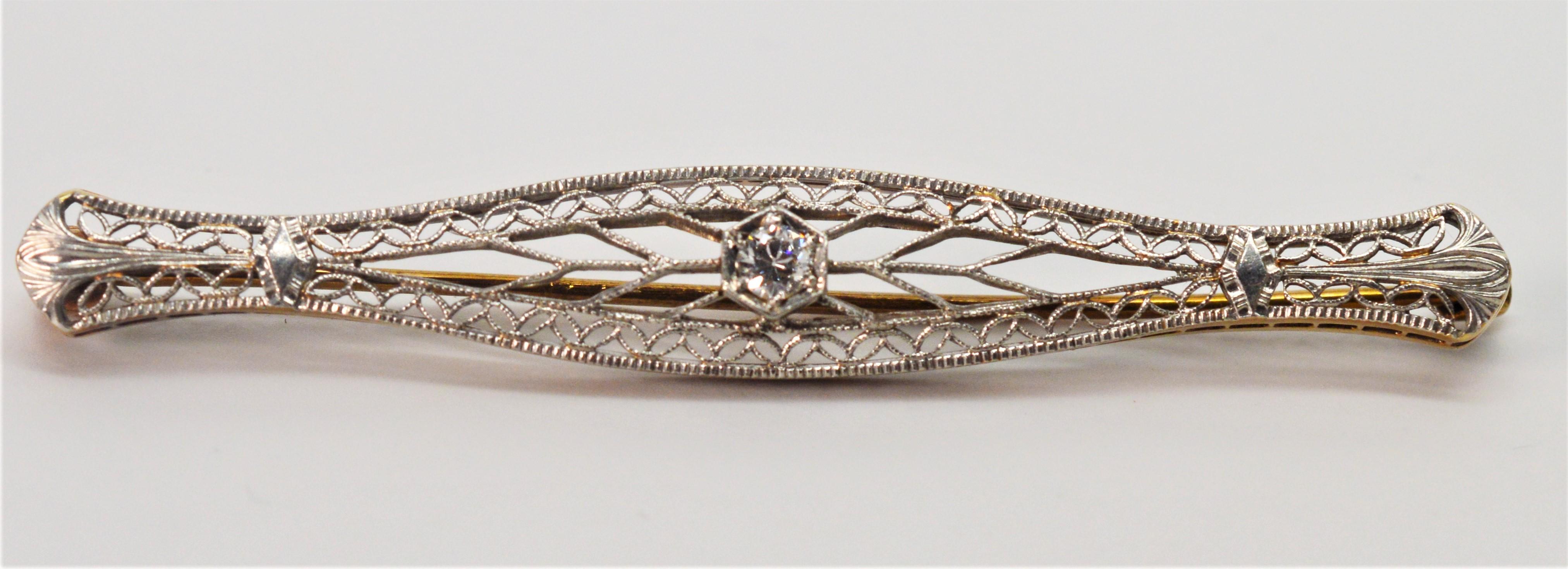 Elegant Art Deco Style fourteen carat 14K gold filigree pin brooch with a center .05 carat miner's cut diamond feature. 
Crafted in classic bowed-shape and measures 2-1/4 inches. Gift boxed. 
