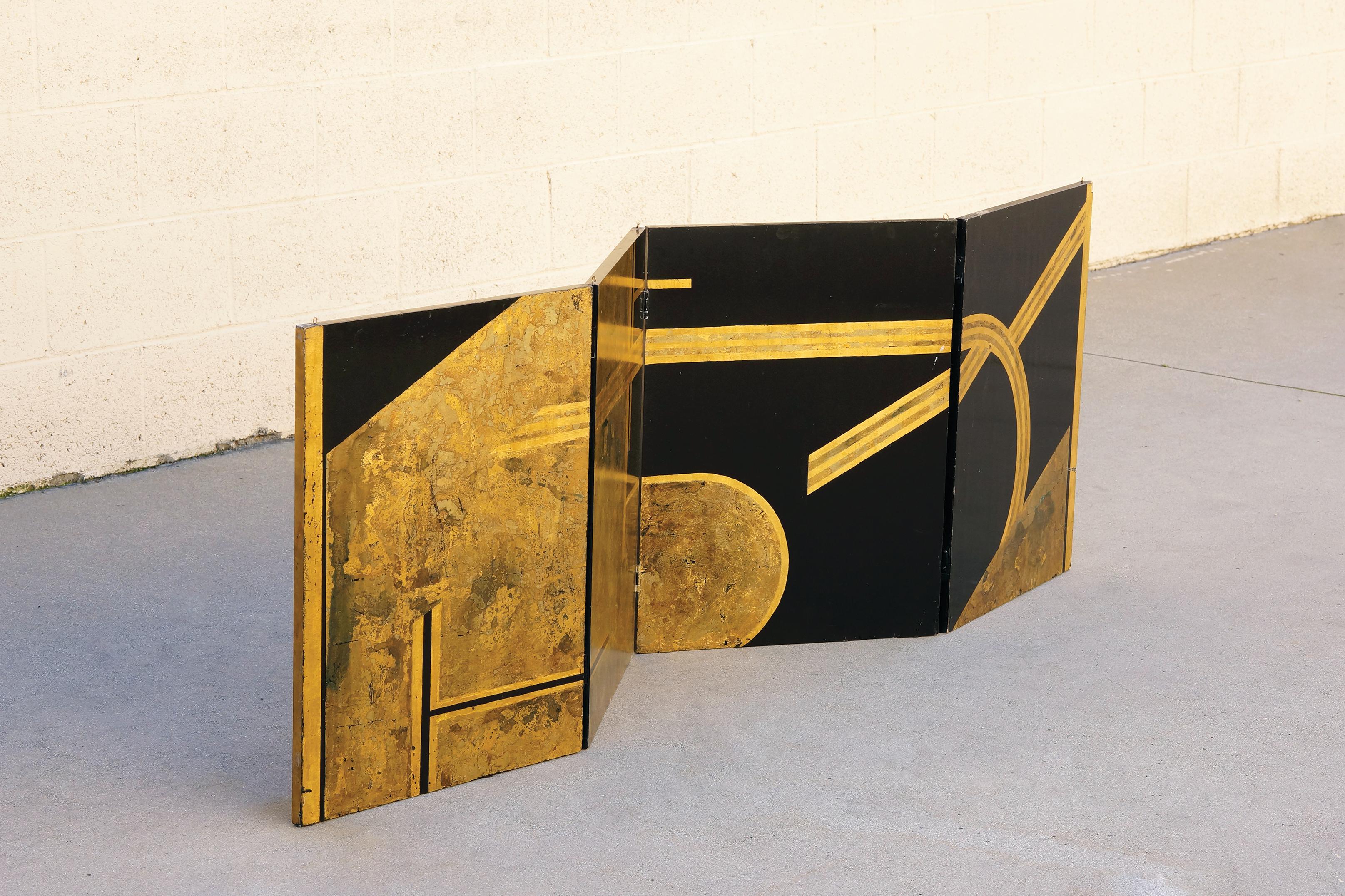 Original Art Deco era folding screen composed of gold leaf and black lacquer on wood panels. Four hinged panels in total comprise this 6ft piece. While it is constructed with hooks to be mounted from the ceiling, it can be utilized in a number of