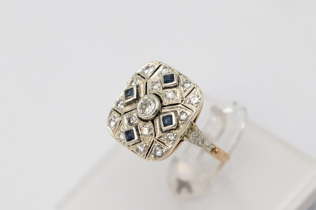 El anillo de oro antiguo procede probablemente de Austria-Hungría de finales de los años 30 y 40. 

El estilo hace referencia al estilo Art Déco geométrico de la época.

El anillo está decorado con diamantes y zafiros naturales.

Un diamante central