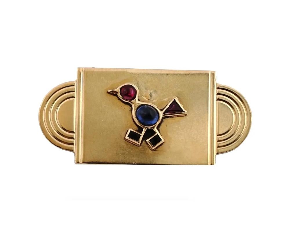 An elegant Art Deco yellow gold brooch decorated with a stylized image of a bird set with ruby and sapphire gemstones. With a safety clutch pin back. Apparently unmarked. Art Deco Fine Jewelry, Gifts And Accessories For Women. Weight 5