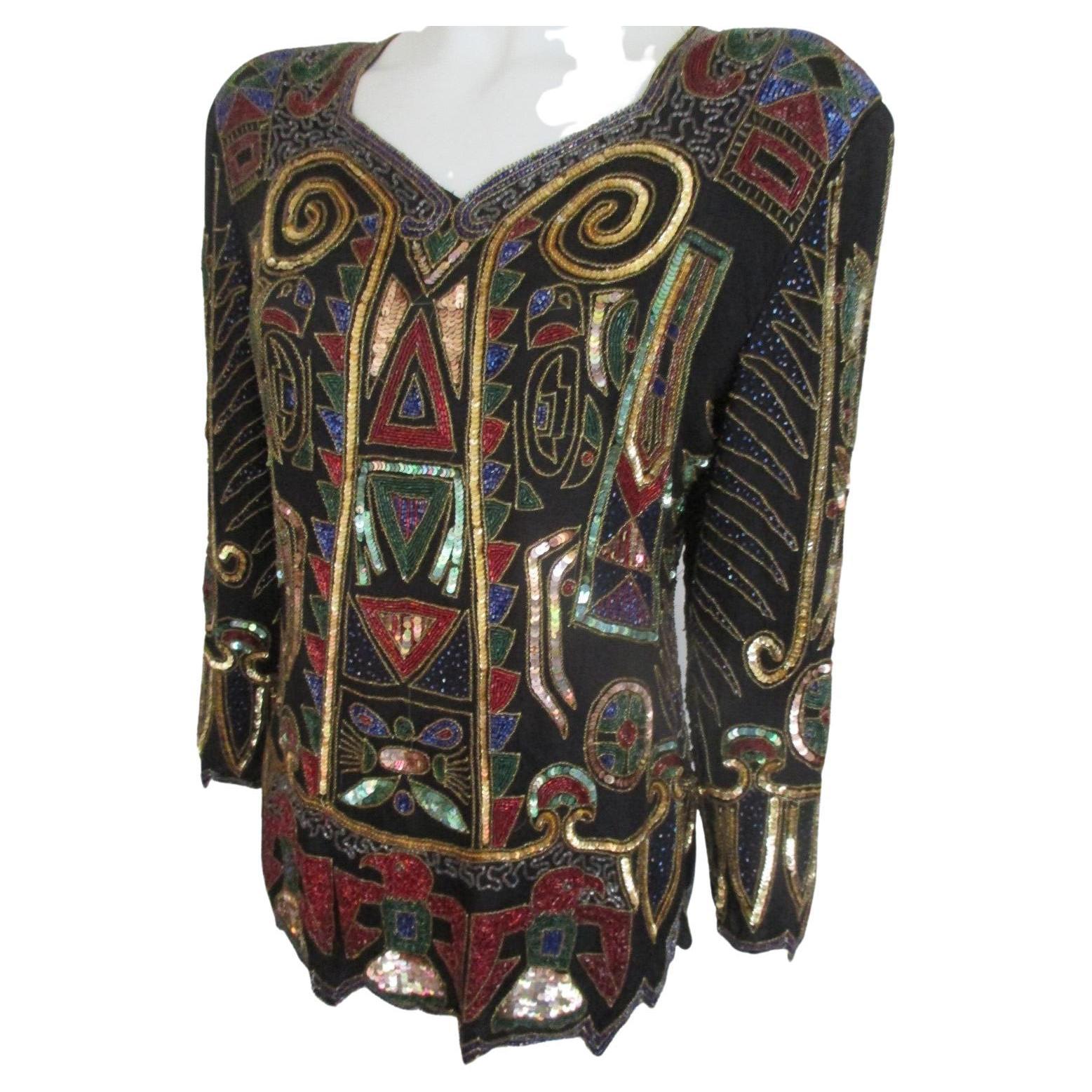 We offer more special vintage sequins items, view our frontstore

Details:
Black top embroidered with beads and color seguin's with goldtone in art deco style
Lined with 2 shoulderpads, which can be removed
Zipper at the back
Pre owned
Size about