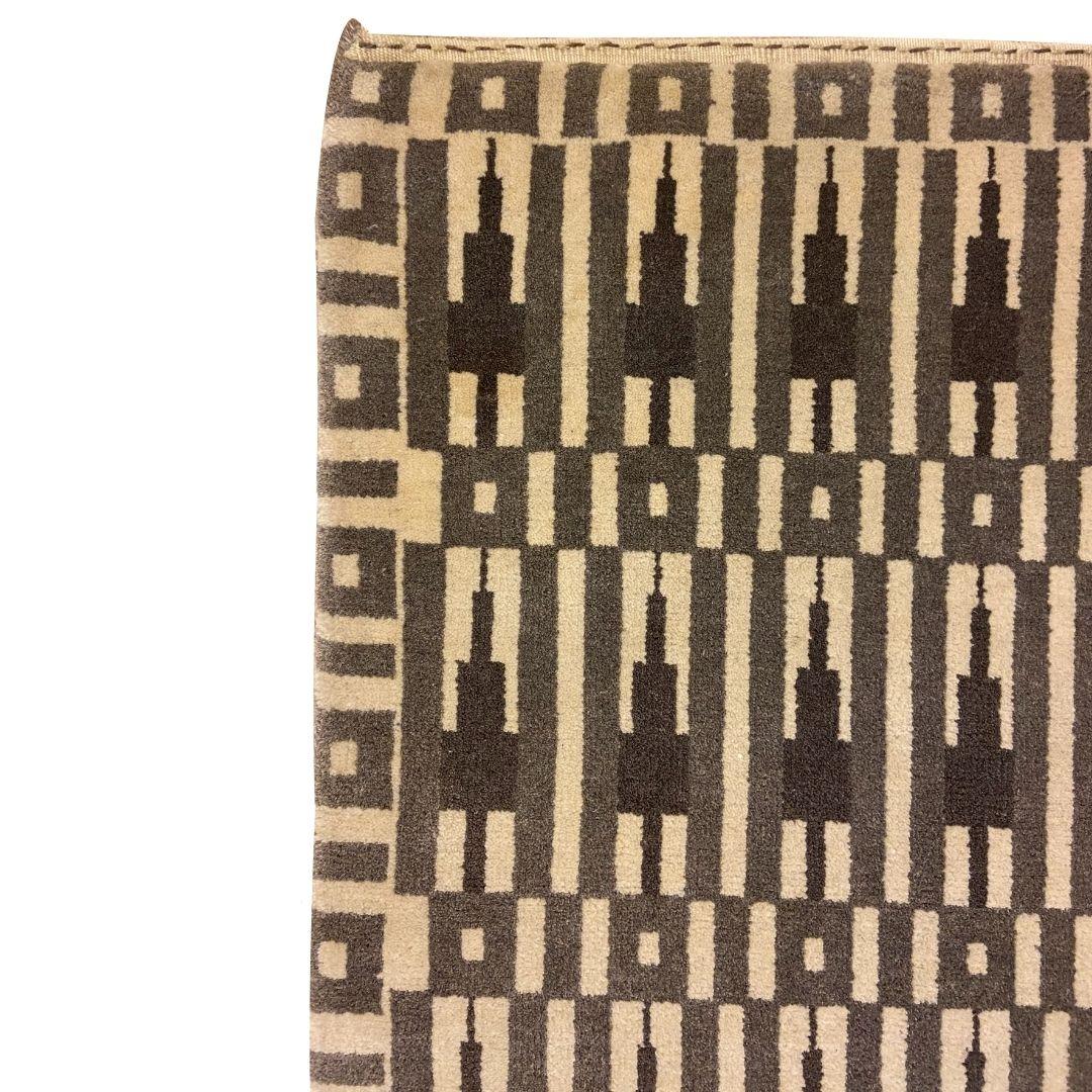 Nei toni naturali del grigio e del crema con qualche tocco di marrone, questo tappeto in lana di 2' x 3' ispirato alle tradizioni estetiche dell'Art Déco si intitola 