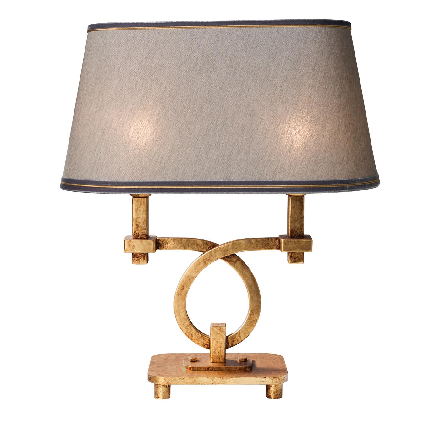 Distinguished by an intriguing metal structure combining curved and straight elements, the captivating design of this table lamp is enriched by a coating in antique gold leaf that balances the cold nuance of gray of the fabric lampshade. Brown