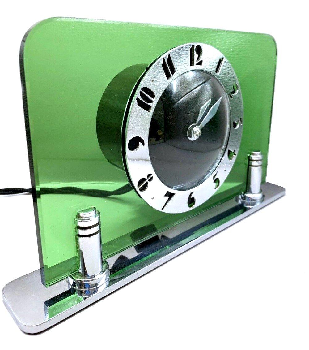 Original 1930s green glass and chrome clock by the English clock makers Smiths. Beautiful green body with black dial face and fretted chrome stylised deco numerals. Fabulous condition, full working order. (We can provide a power adaptor so the clock