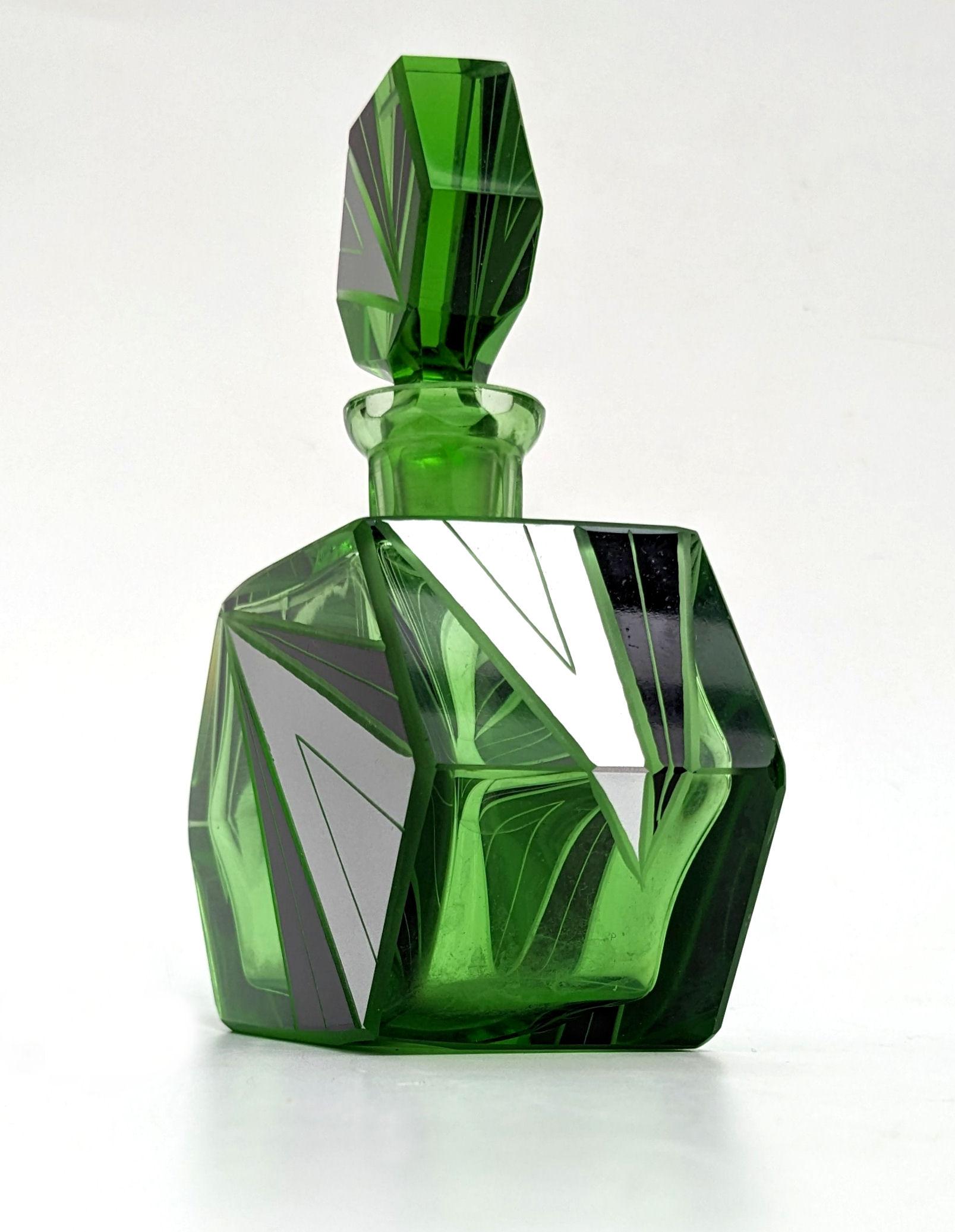 For your consideration is this large Art Deco cut glass perfume bottle. Fabulous shape and design. Features green glass bottle and stopper with silver & black enamel 'lightening' decoration to both pieces. The bottle itself is also an unusual shape,