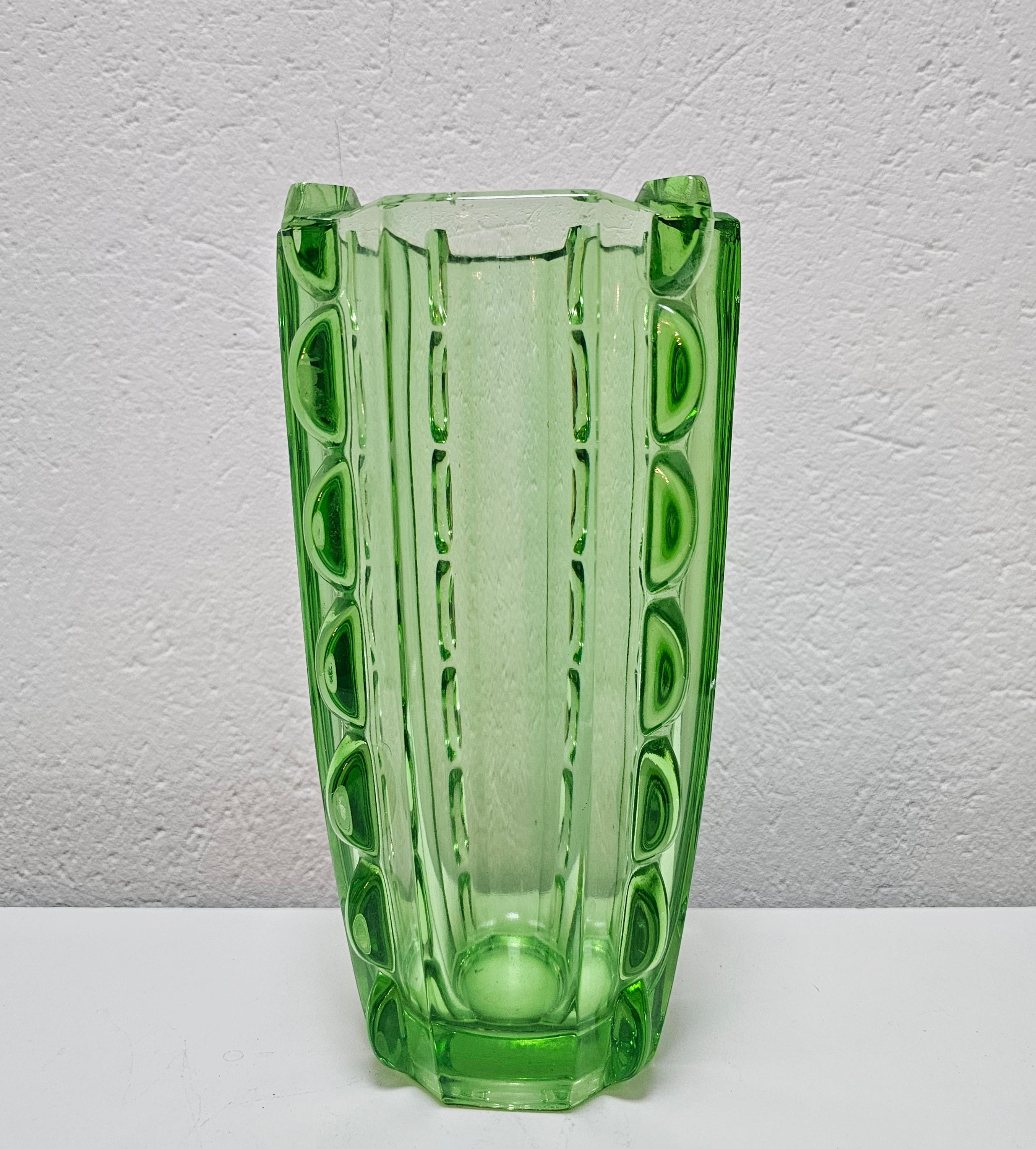 In this listing you will find a beautiful Art Deco green glass vase. It's done in beautiful light green glass and features interesting, geometrical shape and ornaments, inspired by the Italian glass masters. Made in Czechoslovakia in
