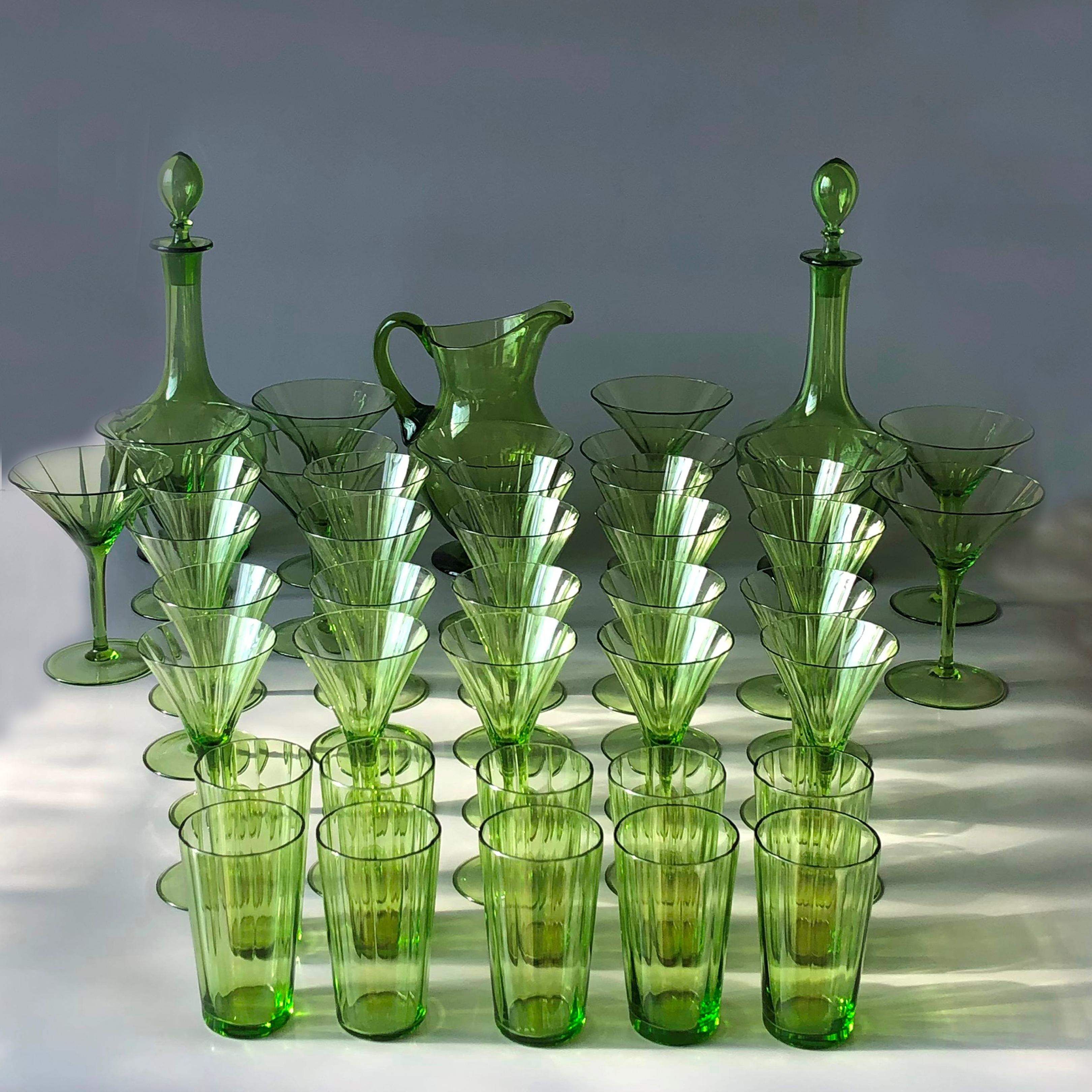 Magnifique ensemble de verres verts soufflés à la main comprenant 10 verres à champagne, 10 verres à vin rouge, 10 verres à vin blanc et 10 verres à eau, ainsi qu'une carafe à eau et deux carafes avec bouchons. 