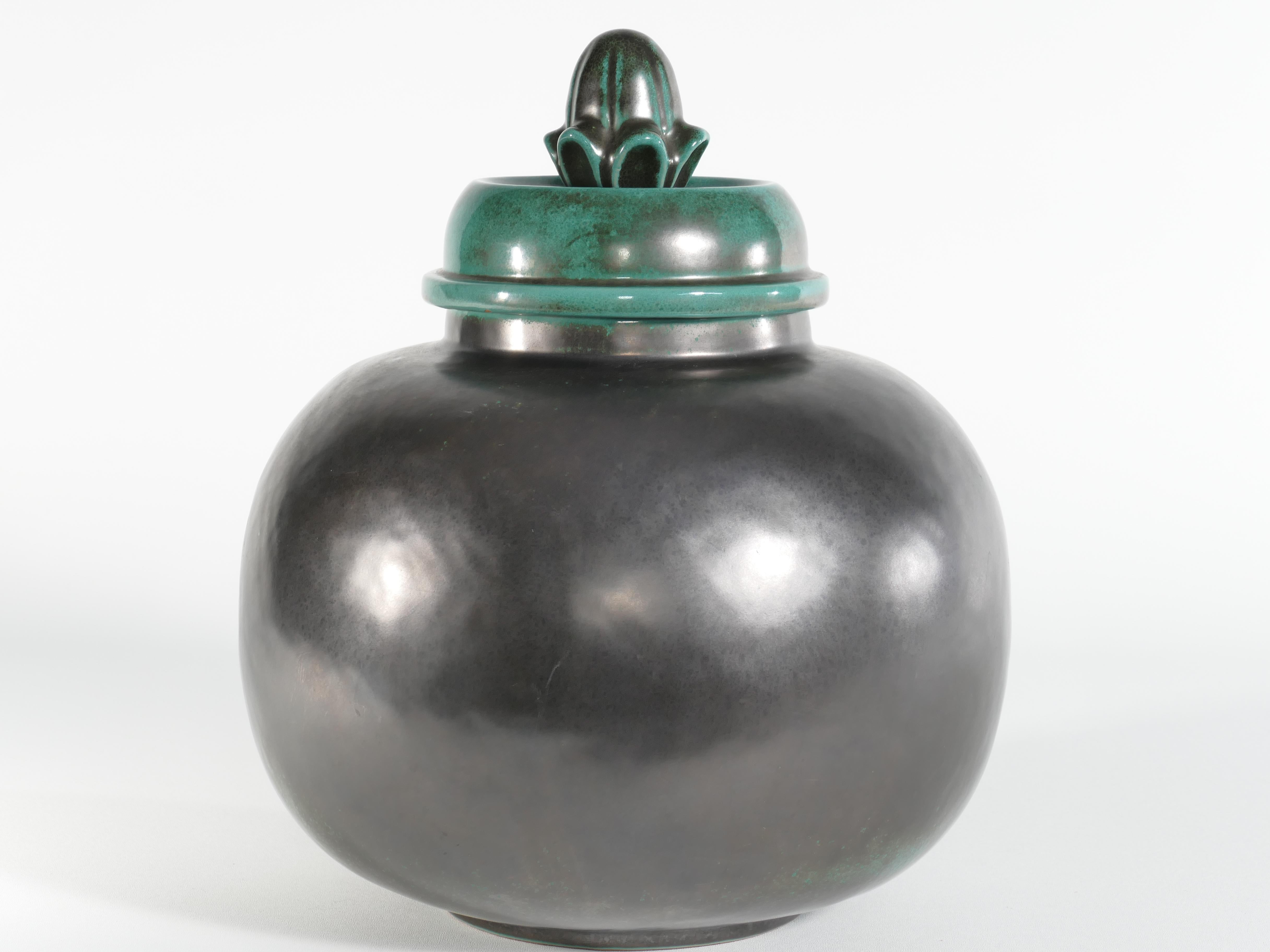 This art deco lidded jar by Anna-Lisa Thomson for Upsala-Ekeby is bathed in a mesmerizing deep green glaze and floral relief decor. This model  (number 2650) was only produced between 1932-1938. 