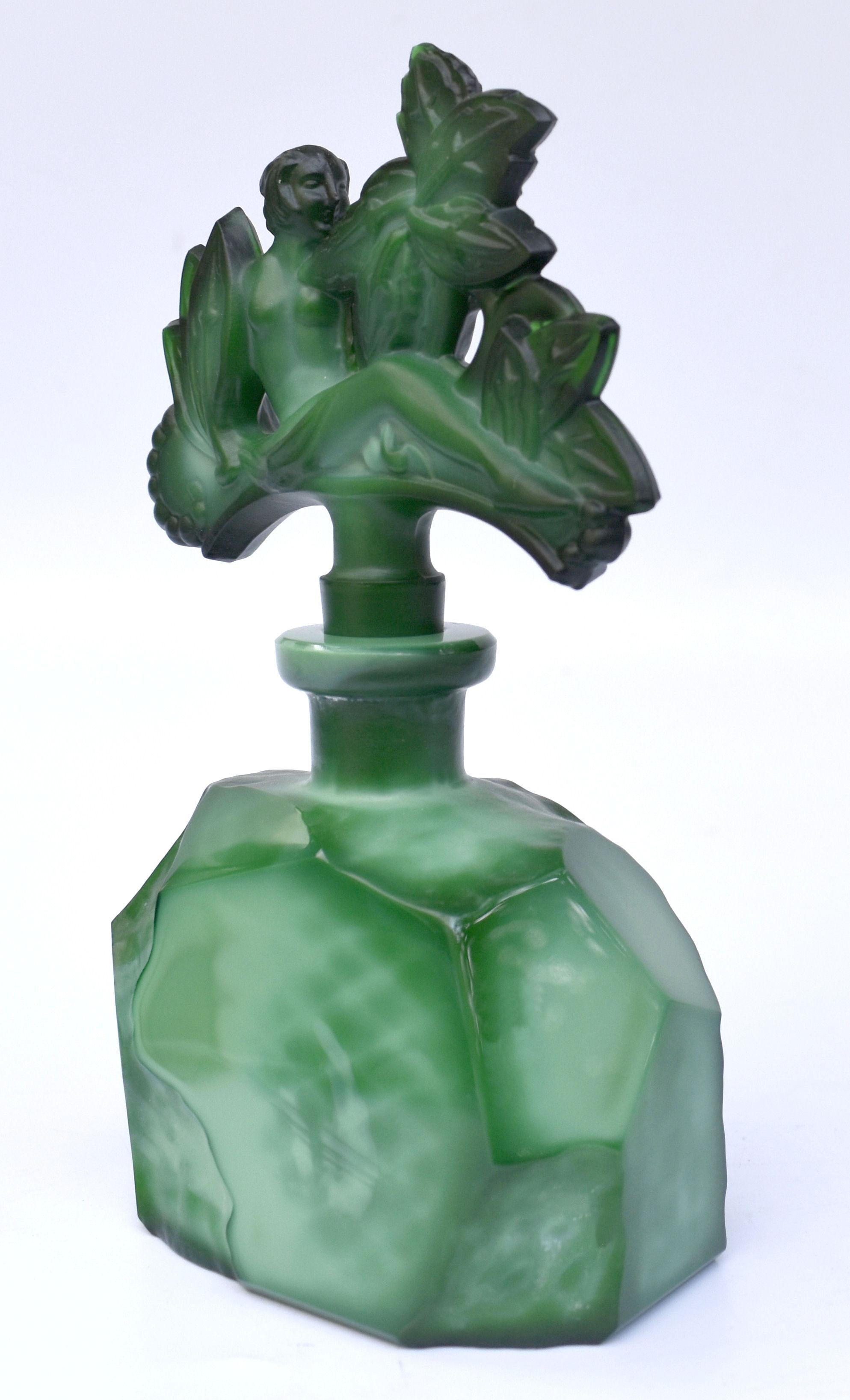 Un très beau flacon de parfum Art Déco en verre de malachite vert avec une figure féminine en relief sur le bouchon. Fabriqué en Tchécoslovaquie, cet étonnant flacon de parfum est attribué à Schlevogt ,Hoffmann et Ingrid qui sont largement reconnus