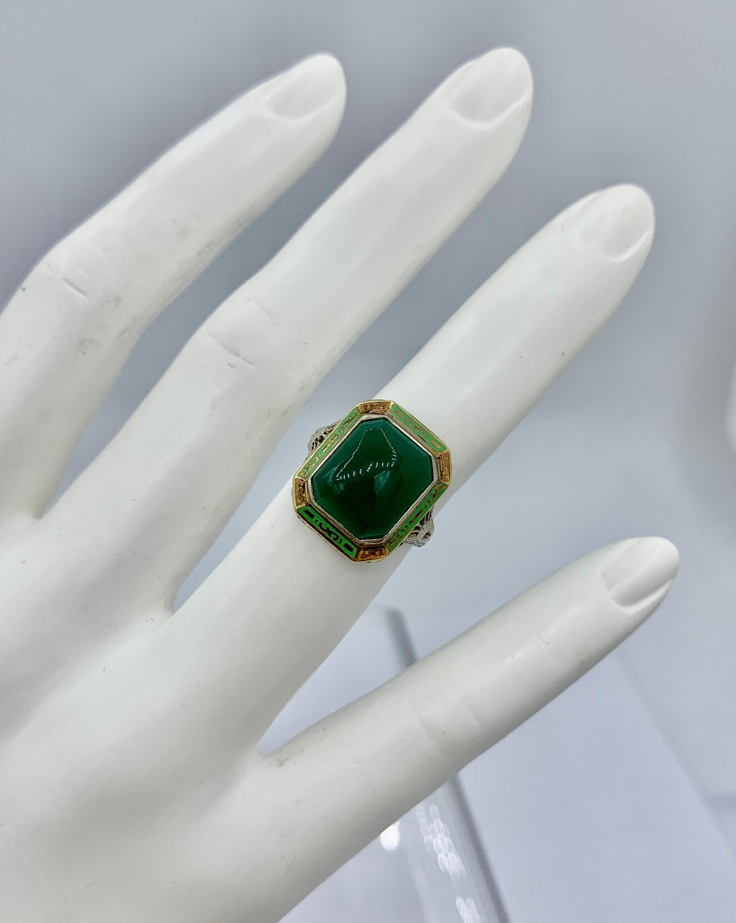 This is an extraordinary antique Art Deco Enamel Ring with a stunning rectangular Green Onyx in the center with gorgeous green and orange enamel decoration surrounding the Green Onyx.  The green onyx is a stunning gem with beautiful color and a