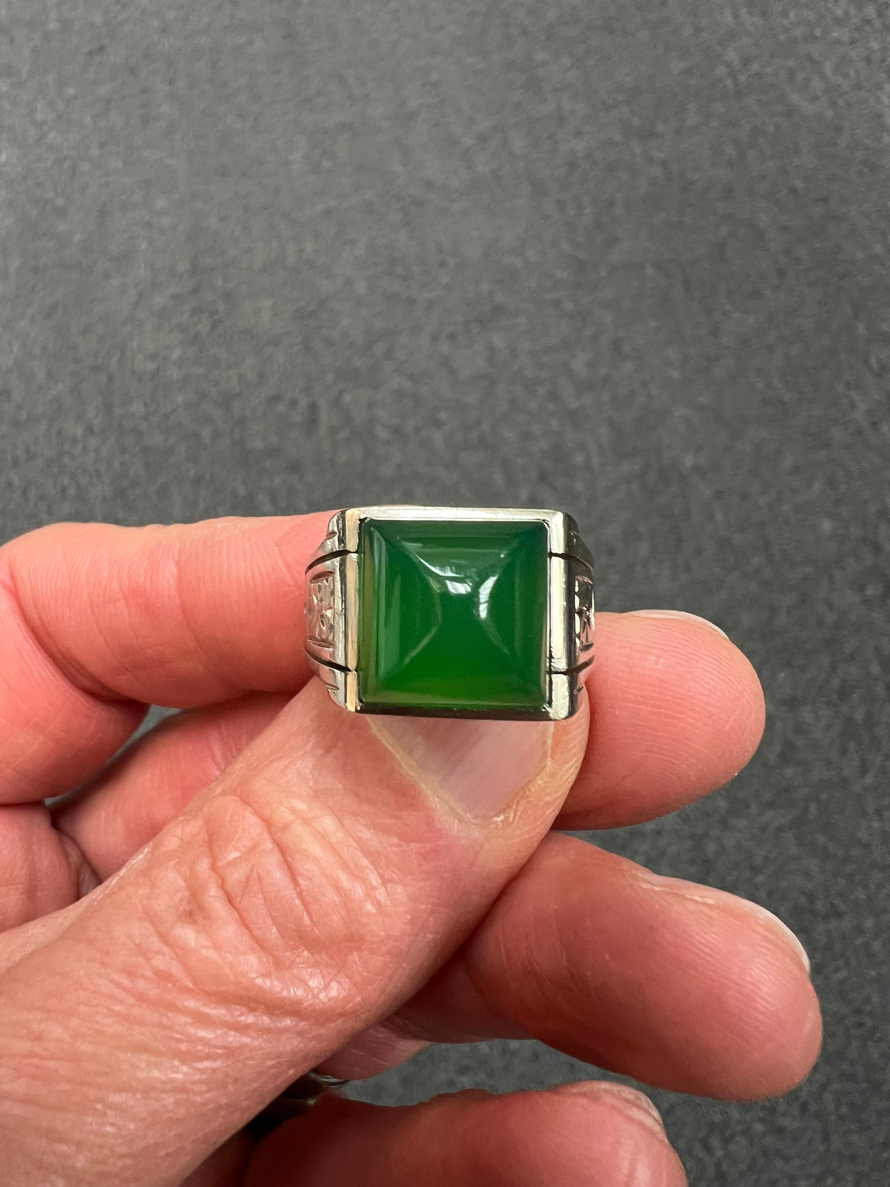 Art Deco green onyx sugarloaf white gold ring, circa 1930s.

The Art Deco Green Onyx Sugarloaf White Gold Ring, Circa 1930s, is a stunning example of the elegant and geometric style that defined the Art Deco period. This ring features a vibrant